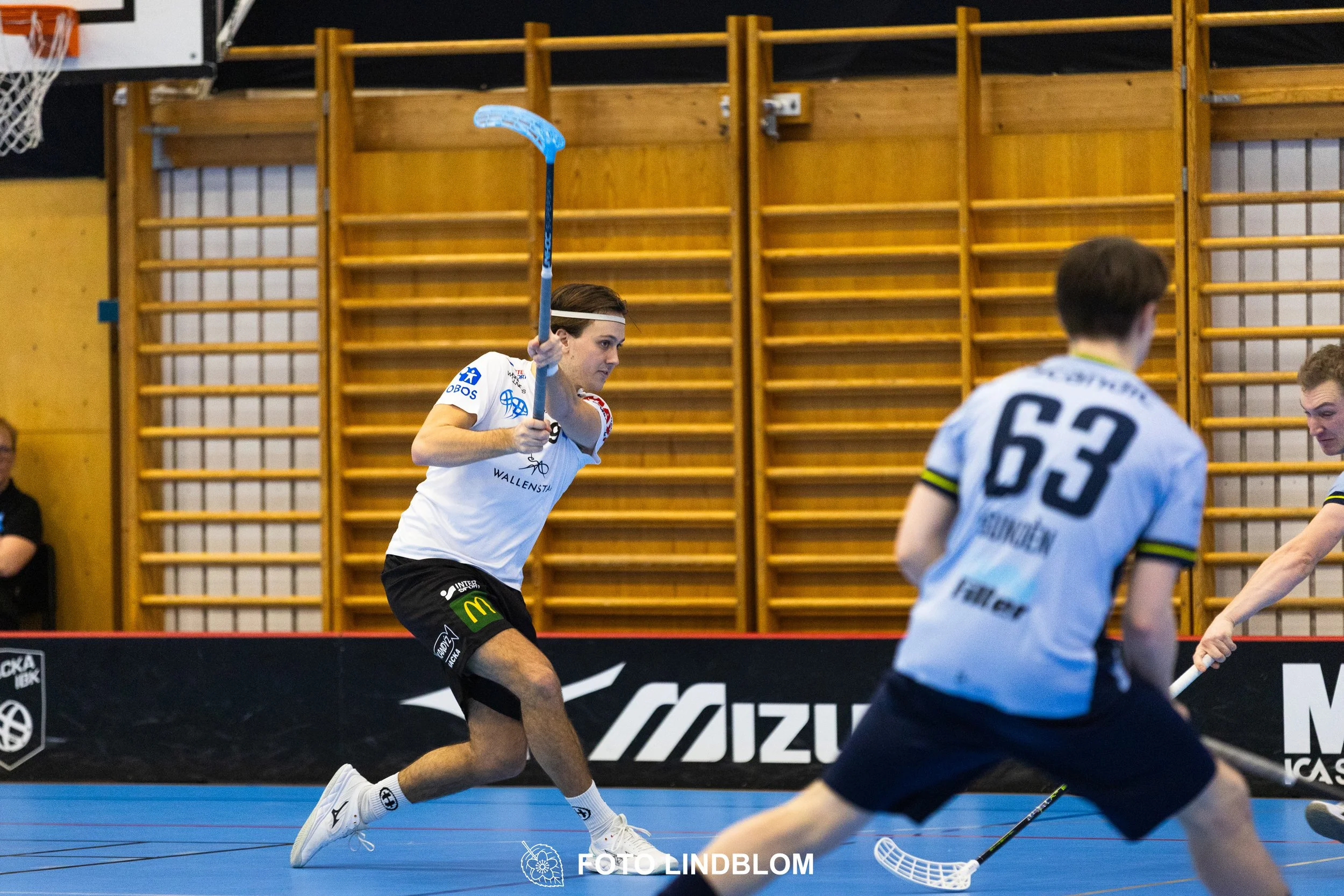 A picture of men playing floorball in Nacka IBK and FBC Sollentuna team gear