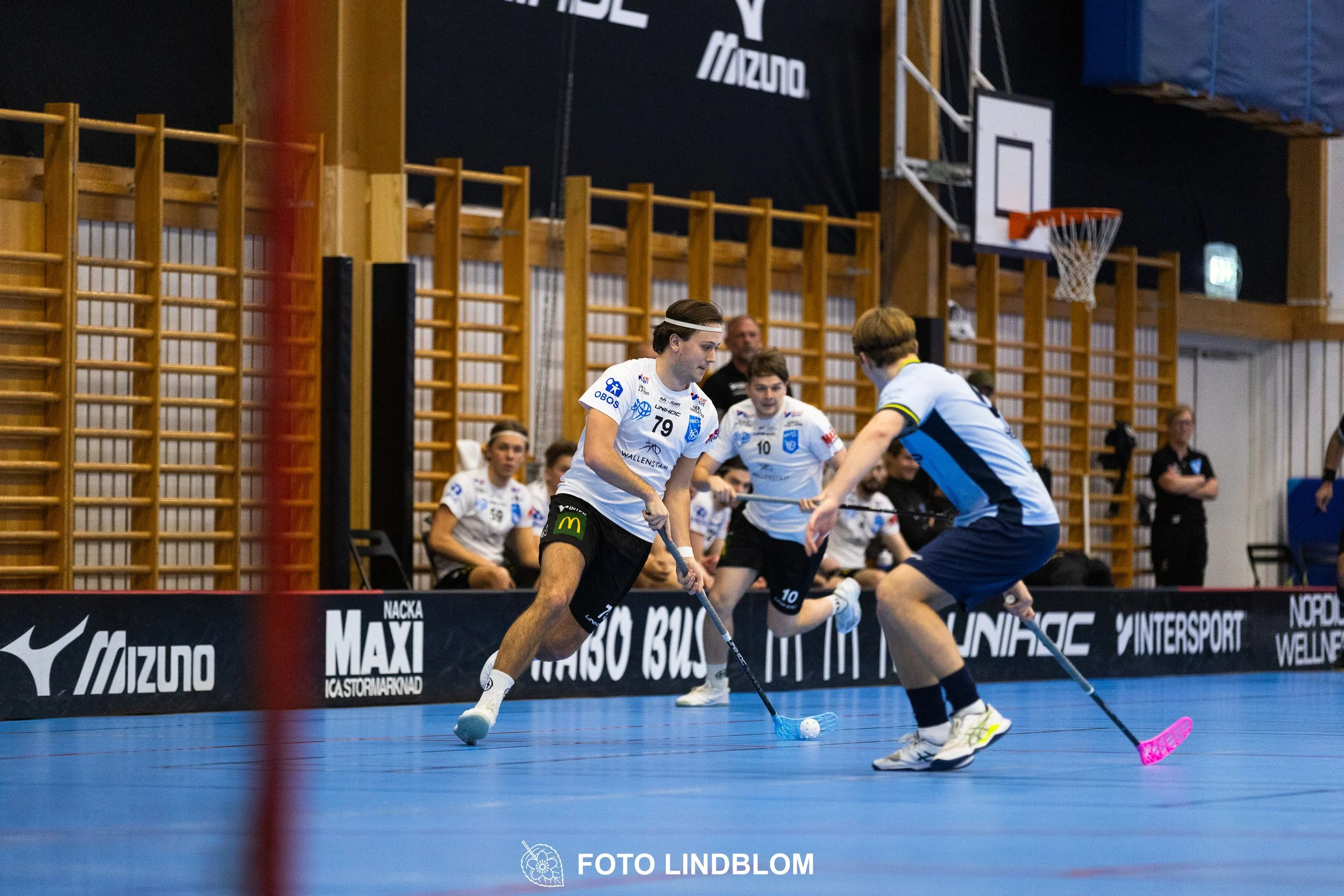 A picture of men playing floorball in Nacka IBK and FBC Sollentuna team gear