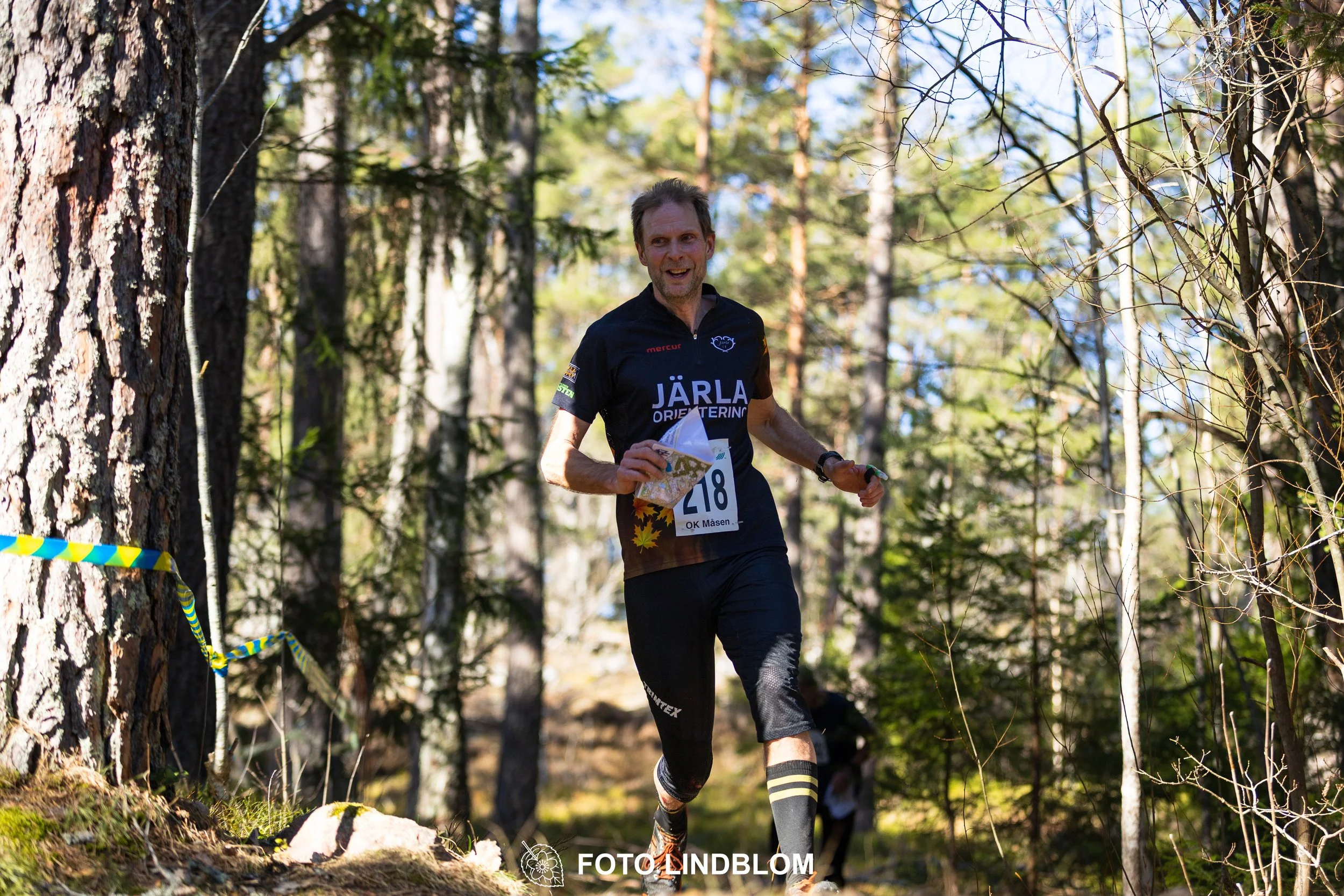 Image from Måsenstafetten 2026 showing orienteering relay teams competing in Swedish forest terrain, taken by Foto Lindblom.