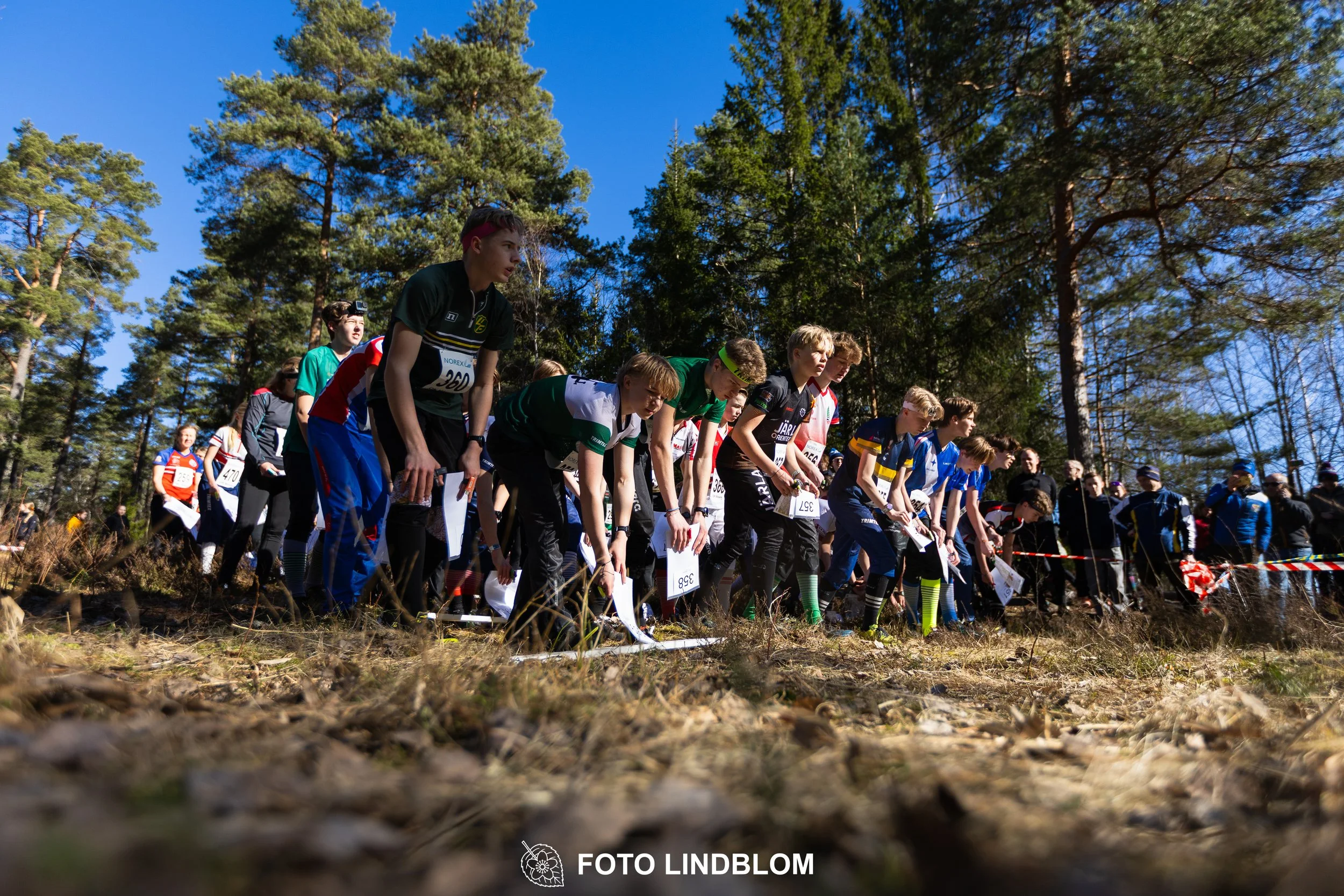 Forest relay orienteering at Måsenstafetten 2026, with teams competing in an endurance event, documented by Foto Lindblom.