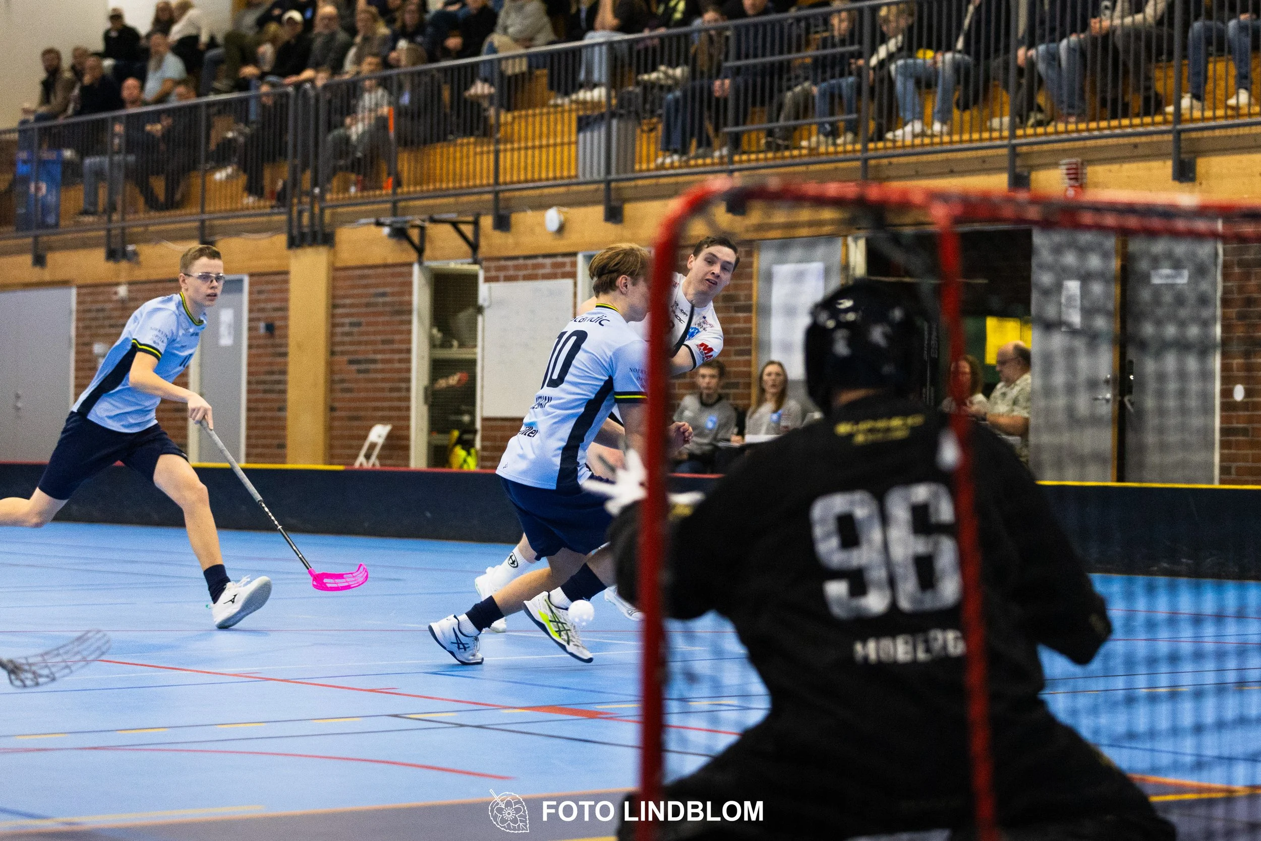 A picture of men playing floorball in Nacka IBK and FBC Sollentuna team gear