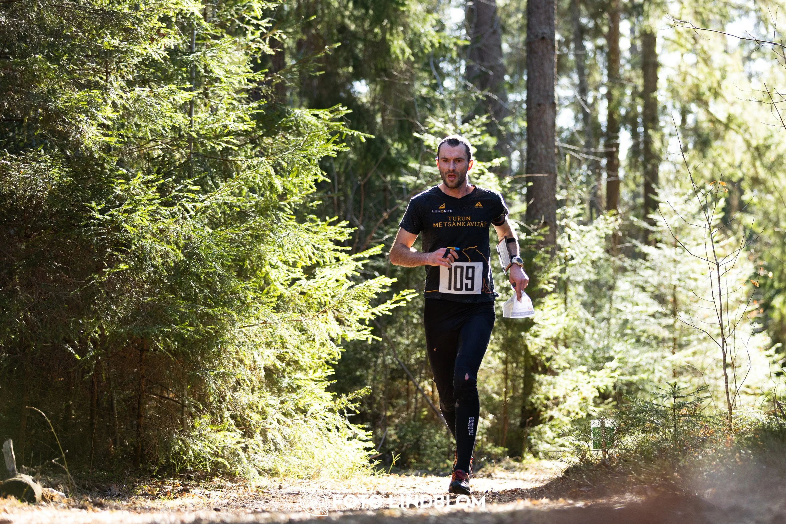 An image from Nyköpingsorienteringen 2026 featuring orienteers in a wooded landscape, shot by Foto Lindblom.