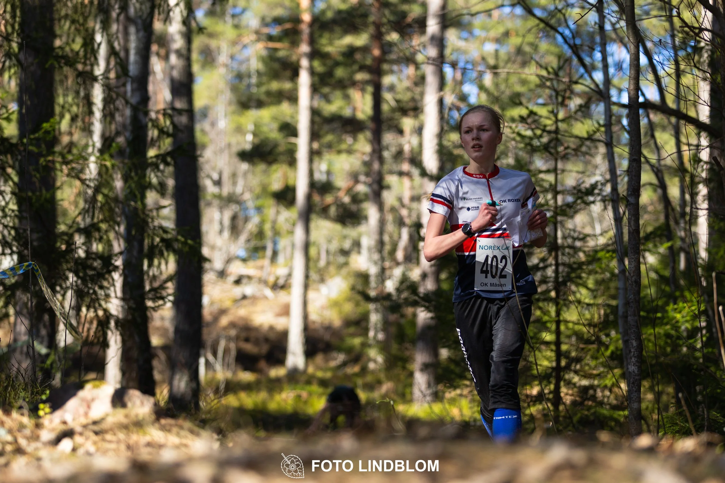 Orienteering relay race at Måsenstafetten 2026, featuring club teams navigating with map and compass, captured by Foto Lindblom.