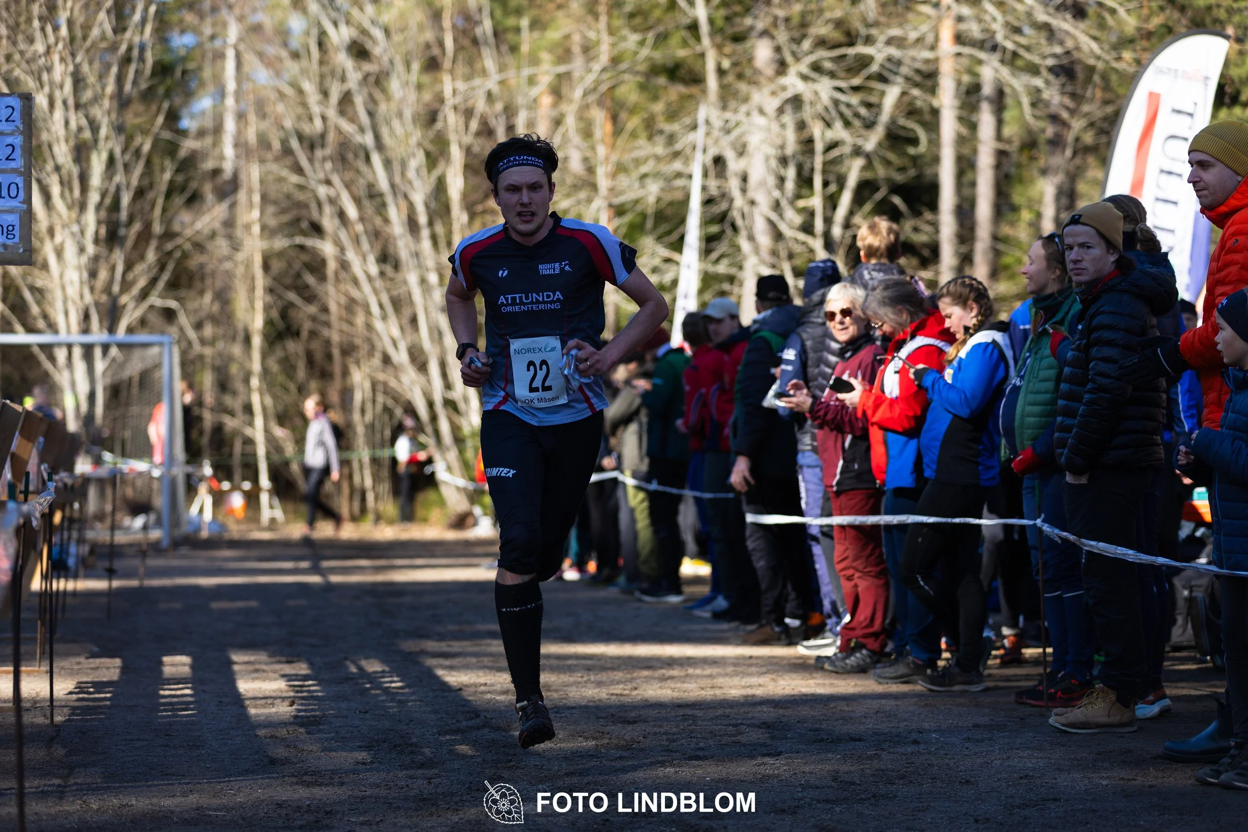 Image from Måsenstafetten 2026 showing orienteering relay teams competing in Swedish forest terrain, taken by Foto Lindblom.