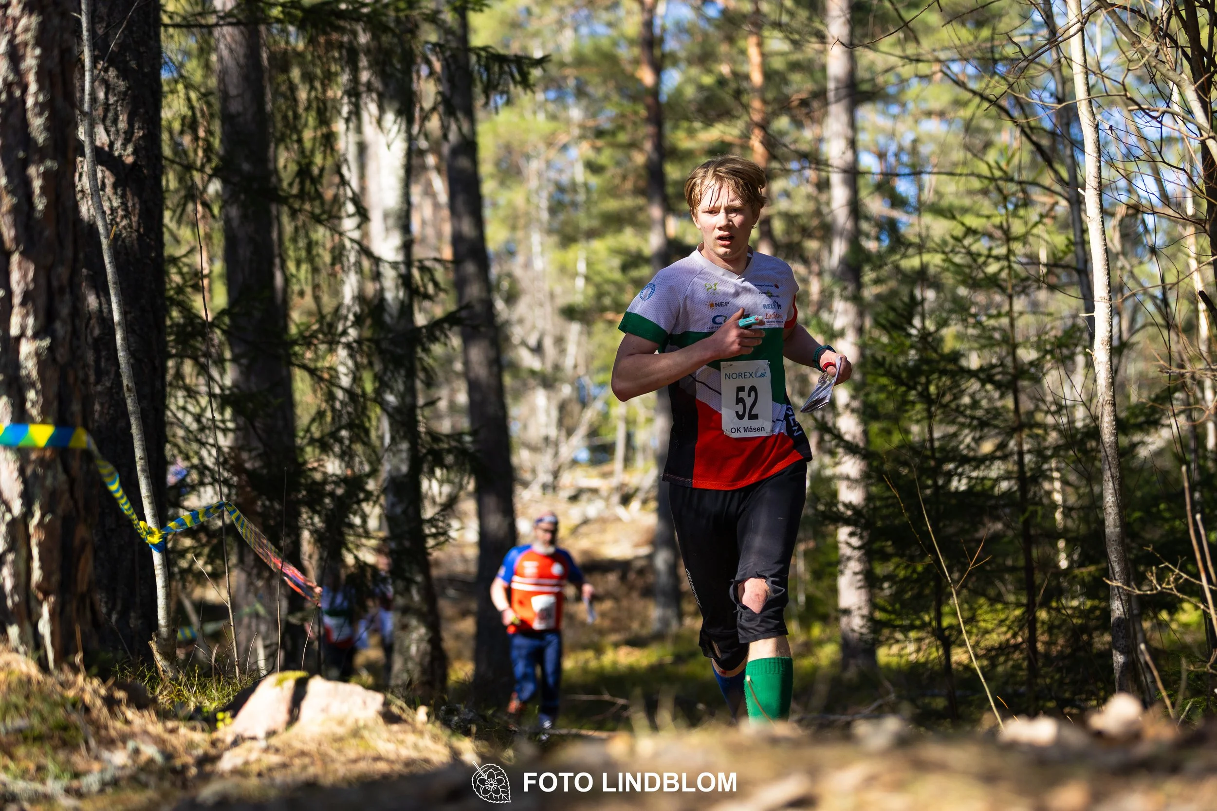 Orienteering relay race at Måsenstafetten 2026, featuring club teams navigating with map and compass, captured by Foto Lindblom.