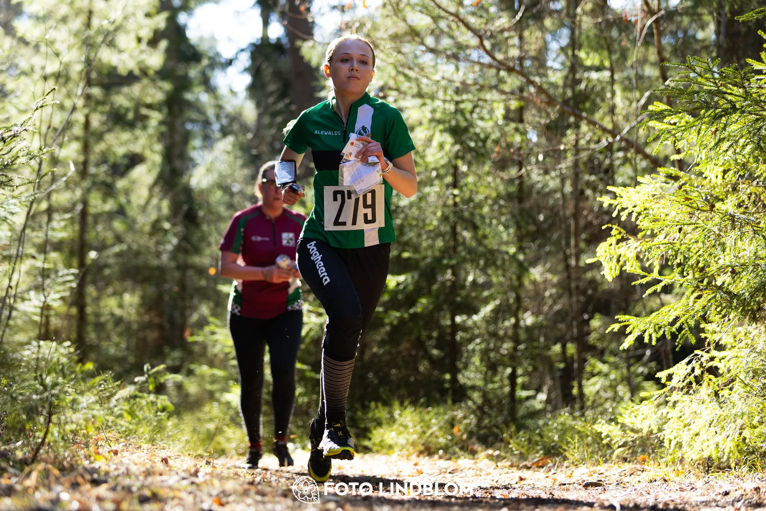 Image from Nyköpingsorienteringen 2026 showing competitors navigating forest terrain, taken by Foto Lindblom.