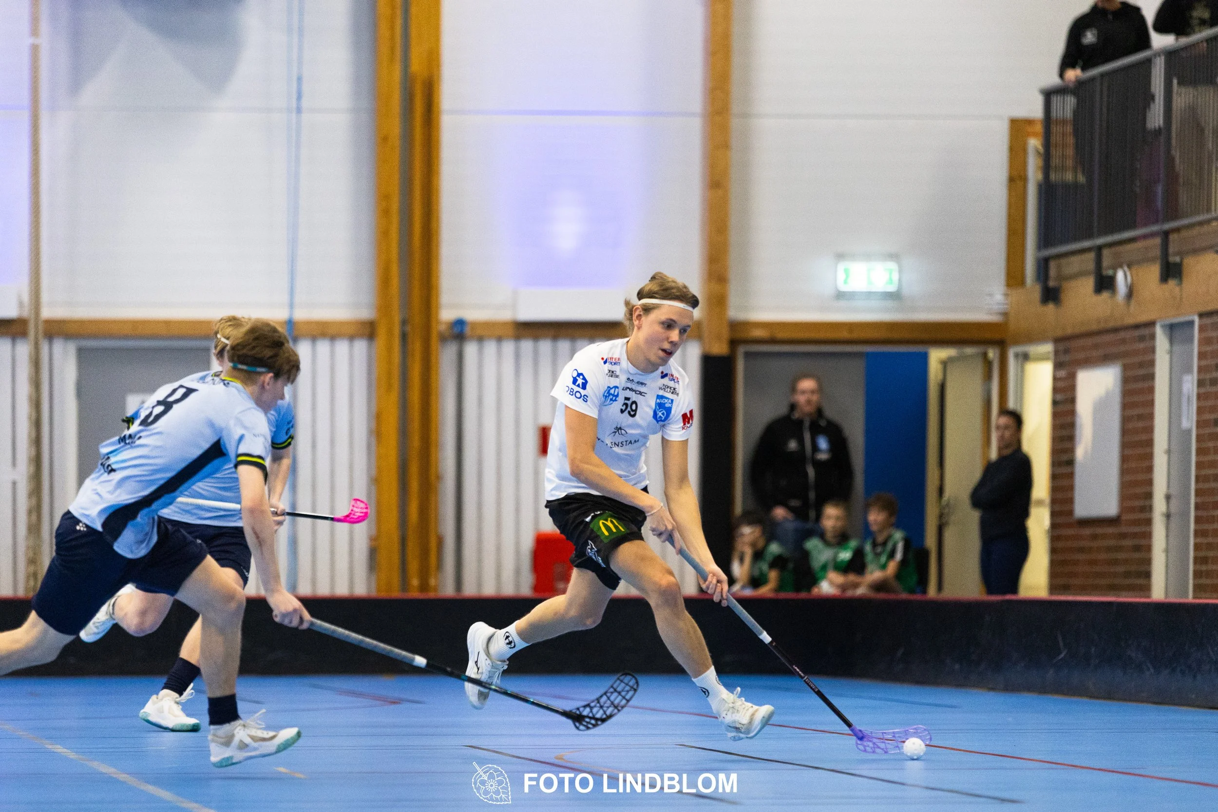 A picture of men playing floorball in Nacka IBK and FBC Sollentuna team gear