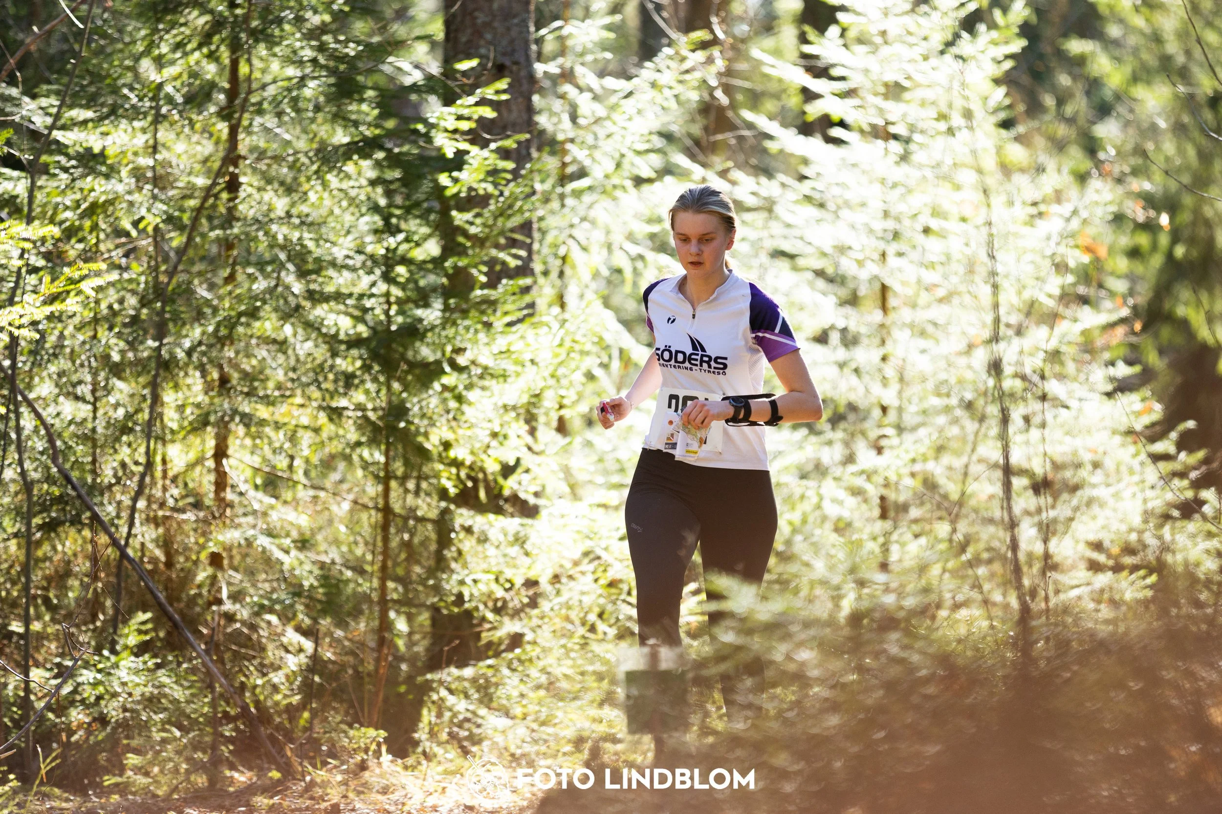 A photo from the 2026 Nyköpingsorienteringen orienteering event in a Swedish forest, captured by Foto Lindblom.