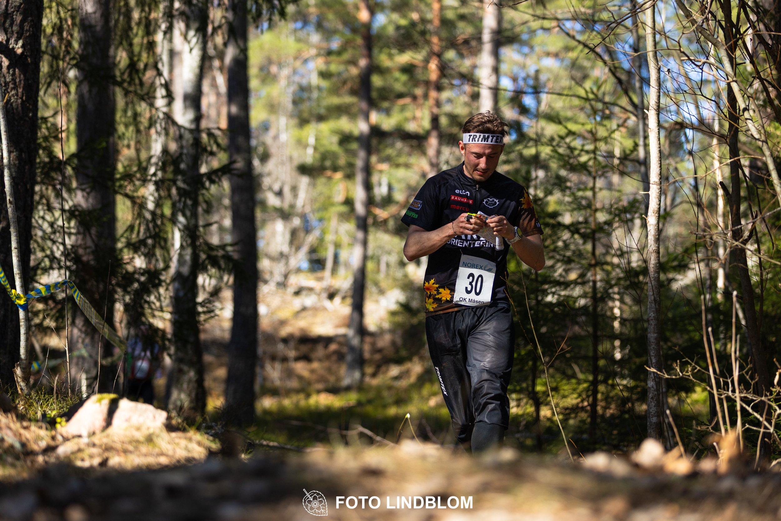 An image from the orienteering relay Måsenstafetten 2026, showing athletes in forest terrain, shot by Foto Lindblom.