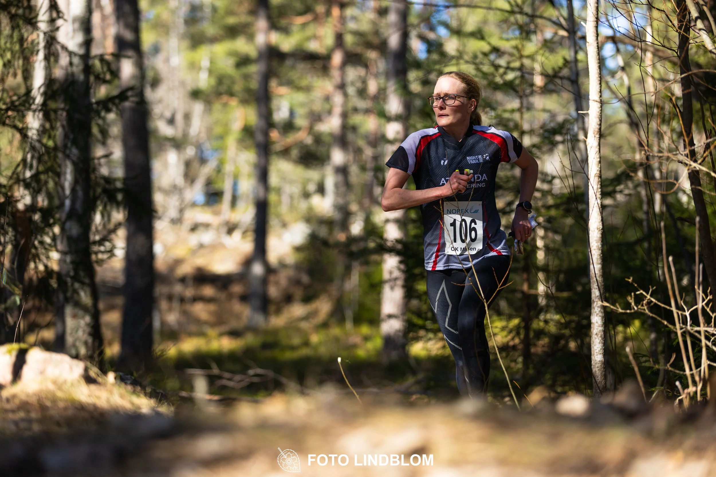 Swedish orienteering relay event Måsenstafetten 2026, with teams racing through forest terrain, captured by Foto Lindblom.