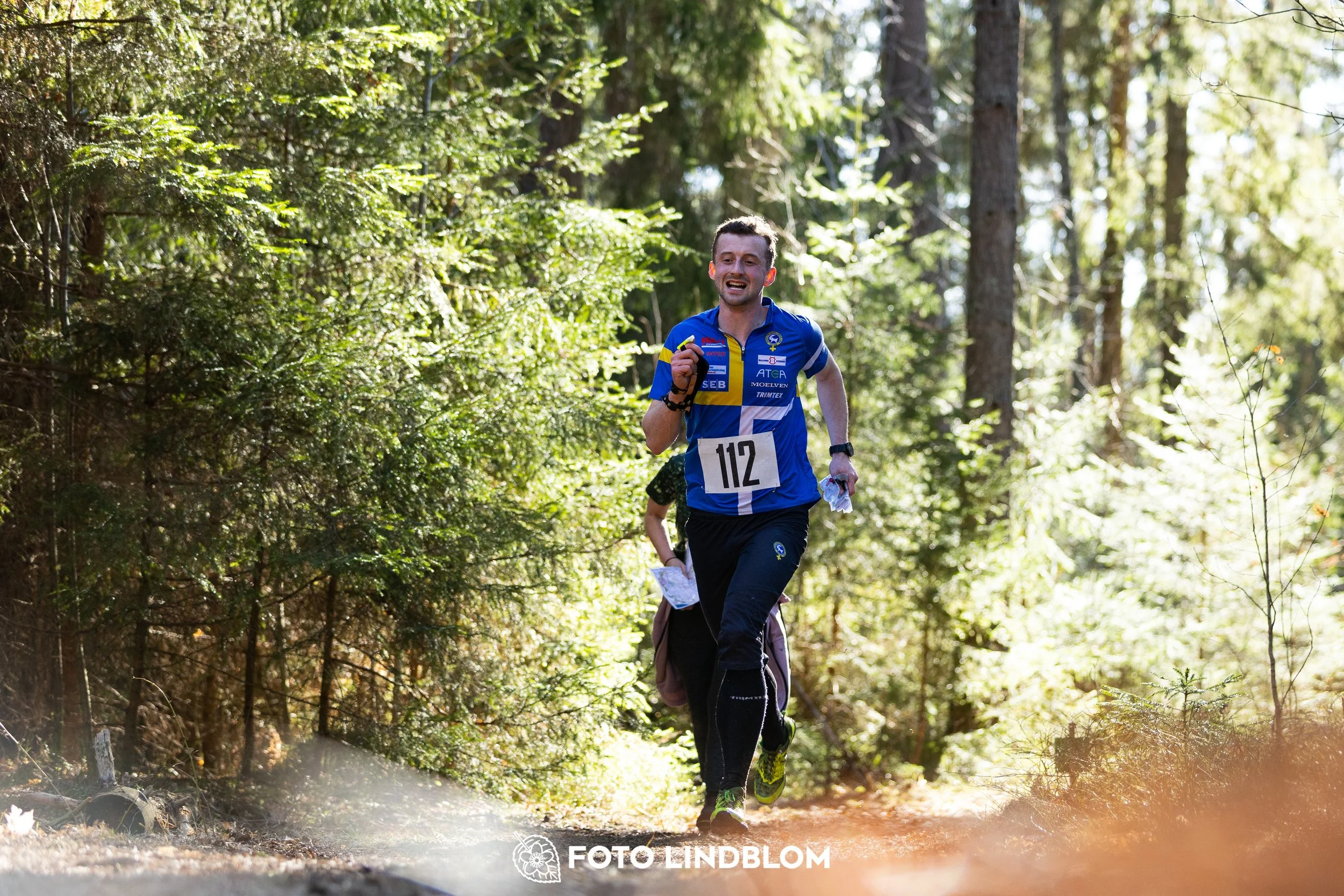 A forest-stage photo from the 2026 Nyköpingsorienteringen orienteering event, taken by Foto Lindblom.