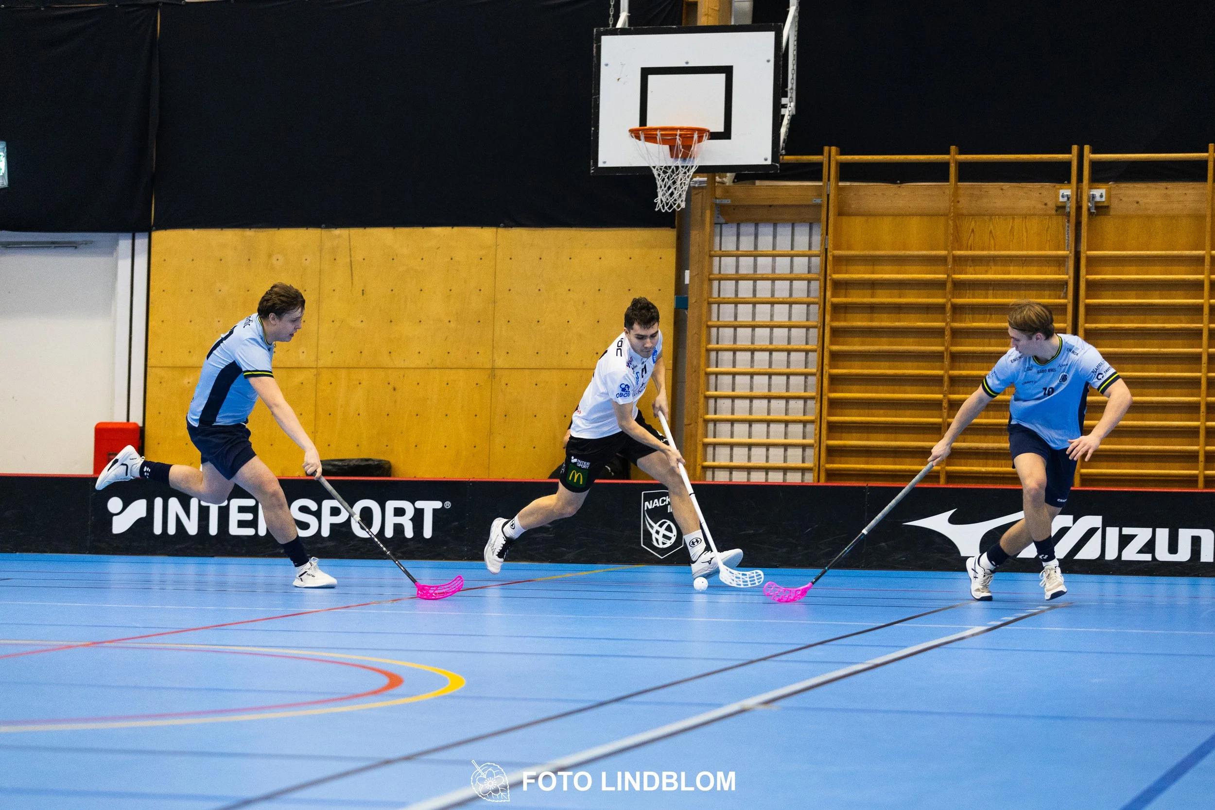 A picture of men playing floorball in Nacka IBK and FBC Sollentuna team gear