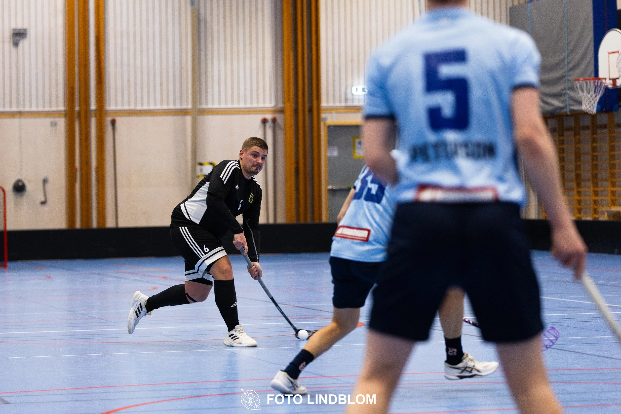 A picture of men playing floorball in Ingarö IF and Älvsjö AIK IBF team gear