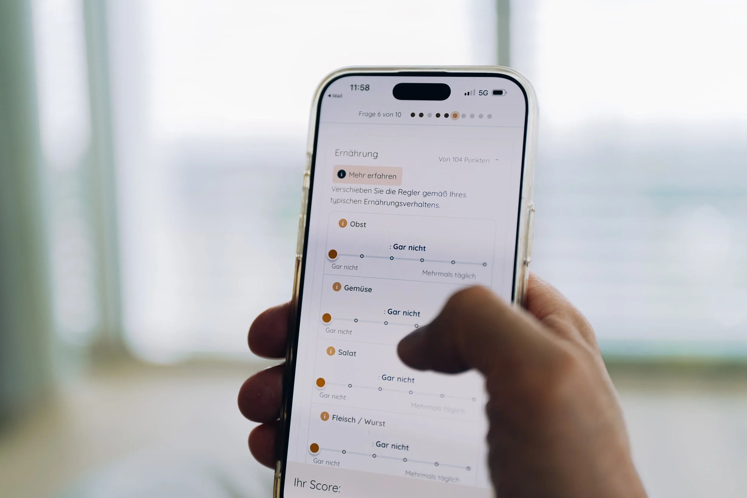 A person holding a smartphone displaying a quiz or survey in German about dietary habits, with options to select frequency levels for various food categories such as fruits, vegetables, salads, and meats.