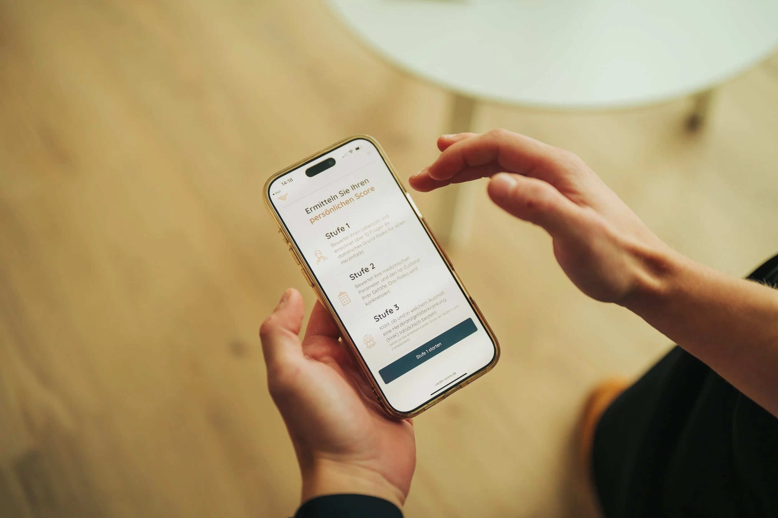 A person holding a smartphone displaying a health app in German, with three levels of personal health score assessment and a start button.
