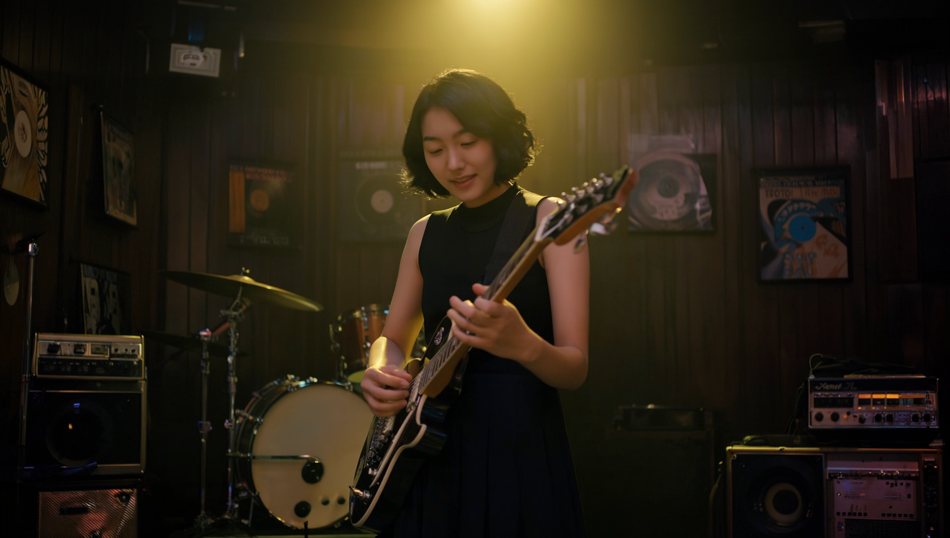 a young East Asian woman playing an electric guitar