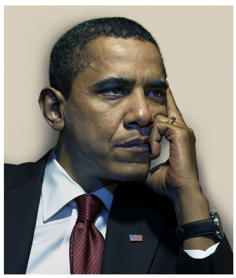 A man in a suit and red tie sitting with his hand on his face, looking thoughtful or pensive.