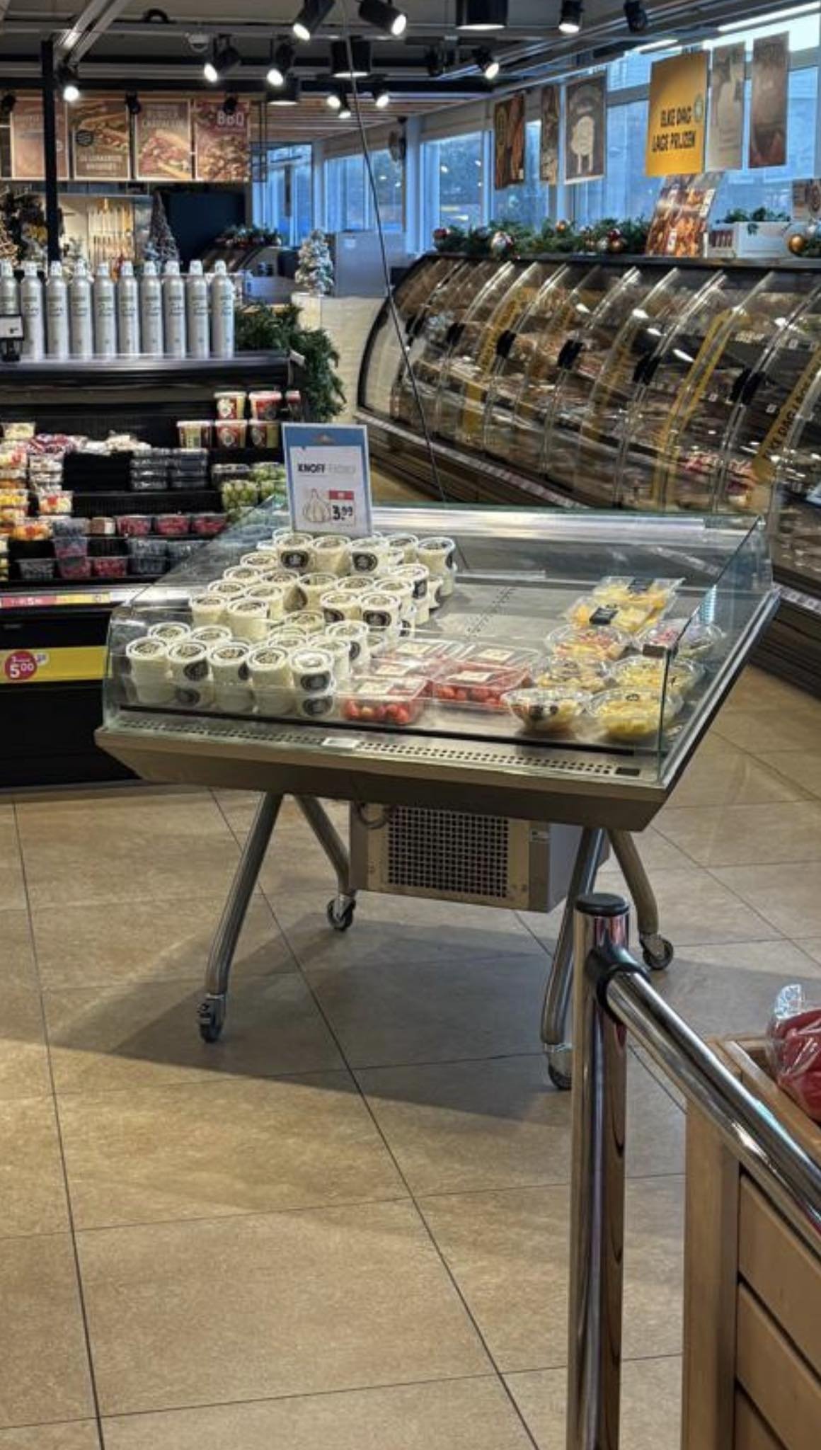 Verkoopautomaat met verschillende soorten desserts, waaronder rolletjes met witte en donkere vullingen, in een supermarkt of delicatessenwinkel.