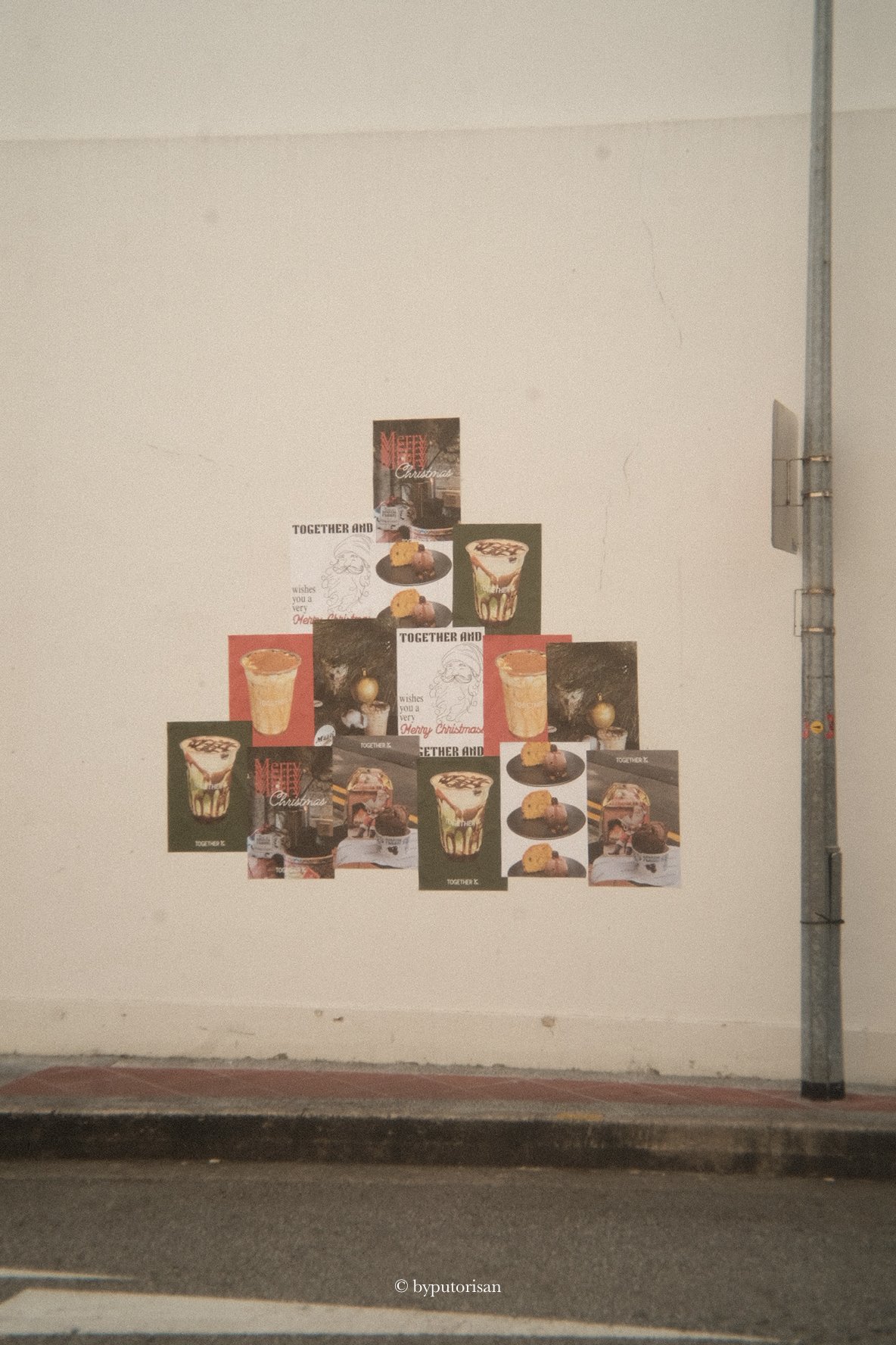 A wall decorated with Christmas photo cards featuring desserts like cakes, pudding, and cookies arranged in shapes resembling a Christmas tree.