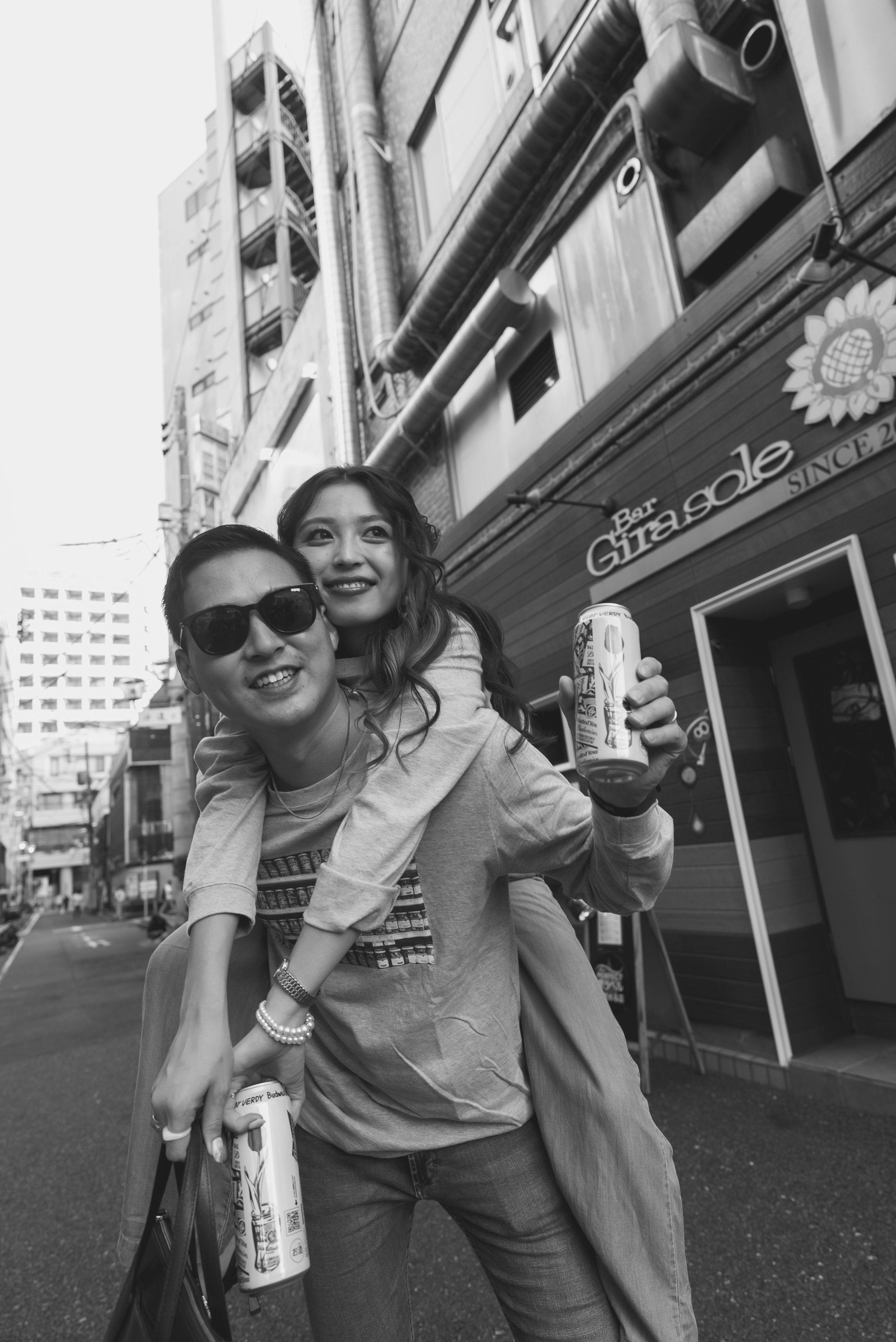 男性と女性が街で飲み物を持ちながら楽しそうに過ごしている。