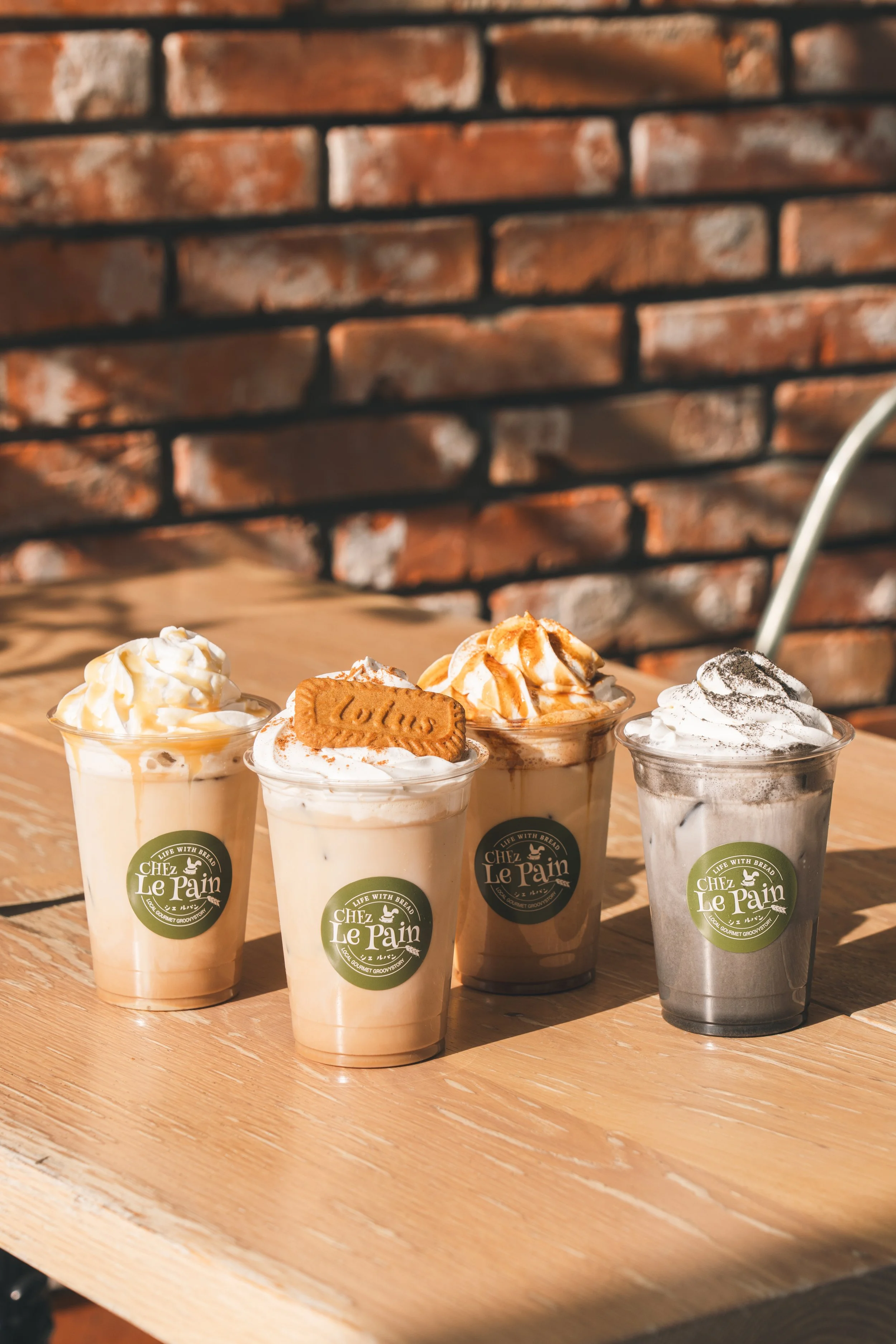 木製のテーブルの上に置かれた4つのアイスクリームドリンク。