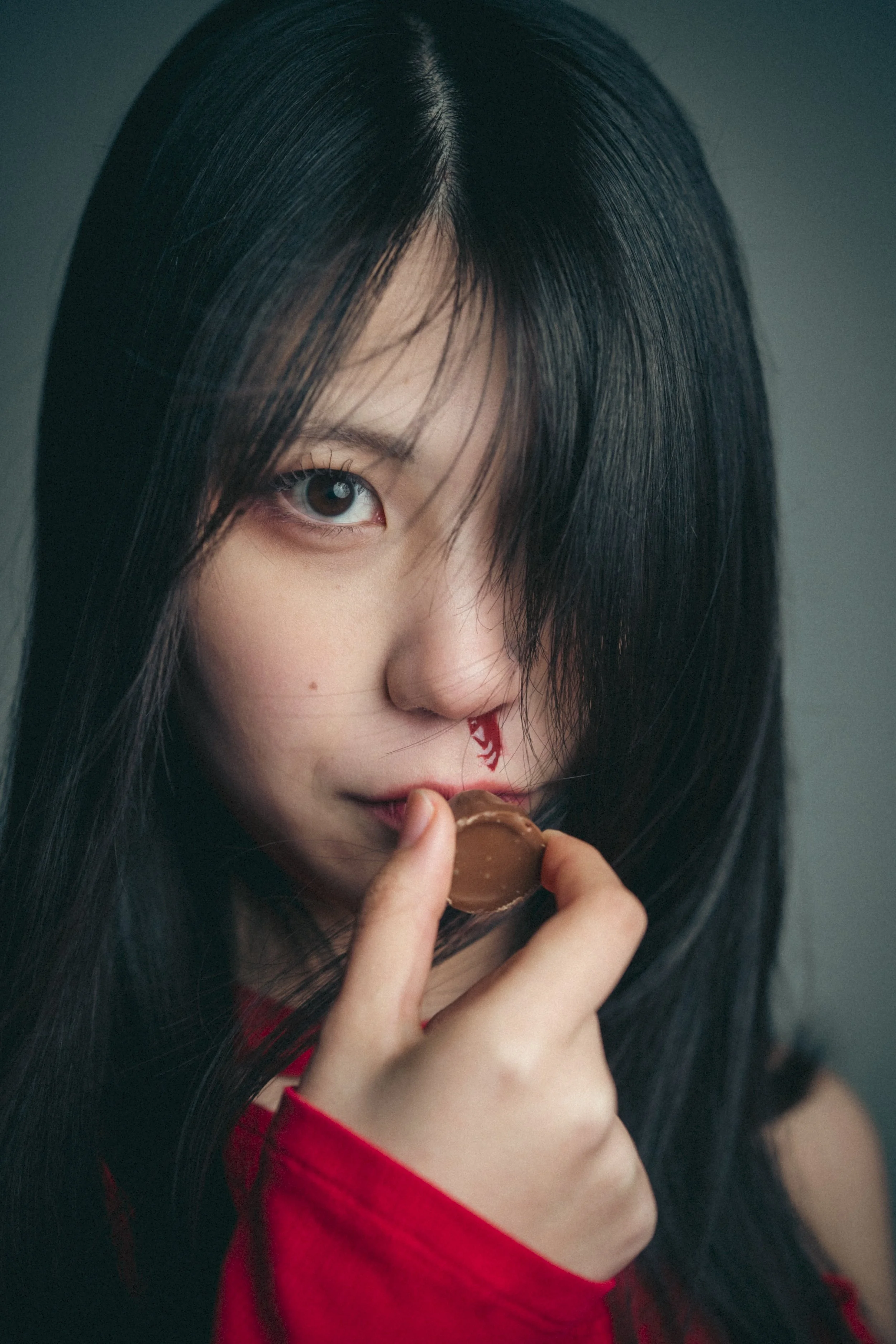 黒髪の若い女性がチョコレートを口にしている。