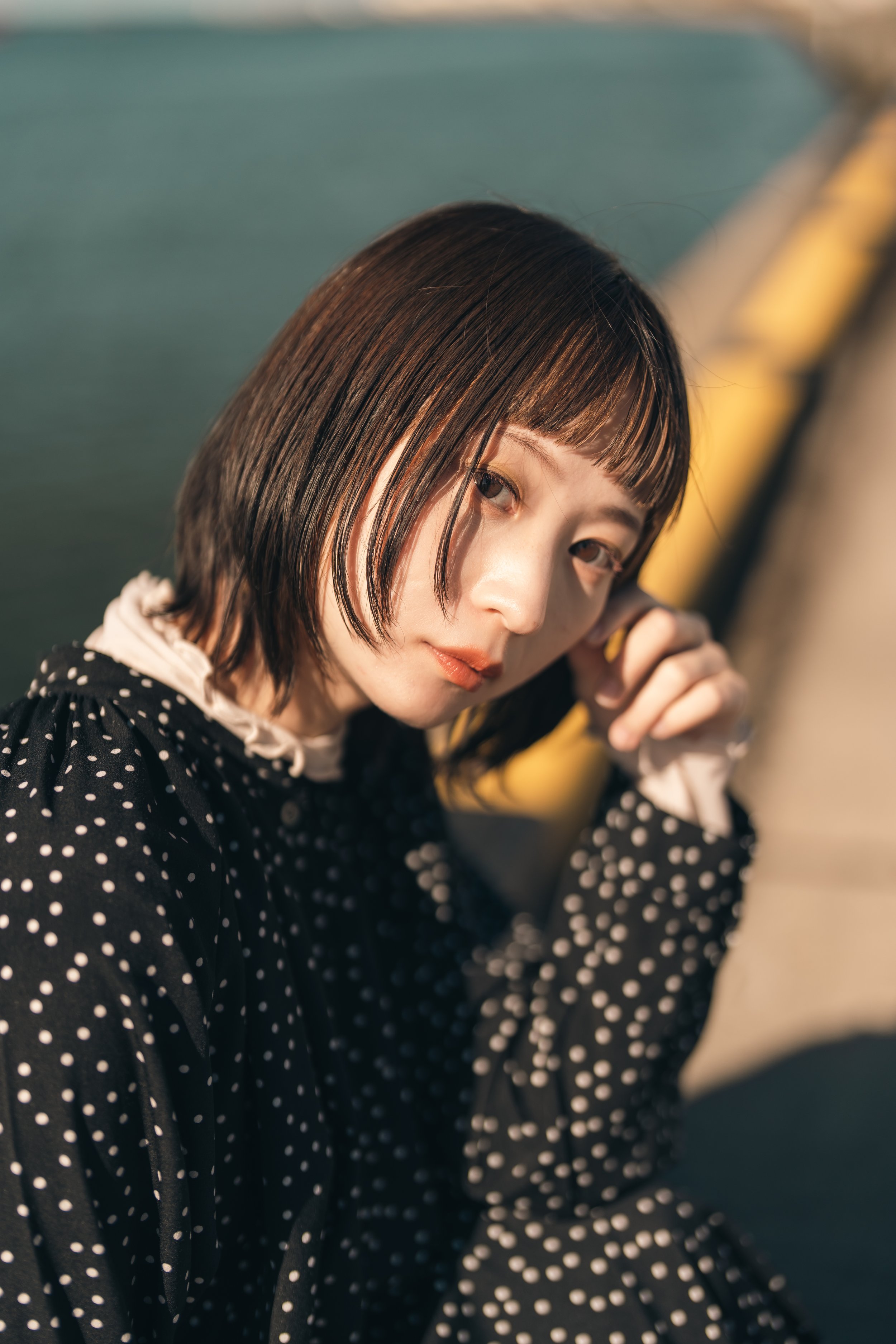 ポーズをとる若い女性、黒いドット柄の服を着ている