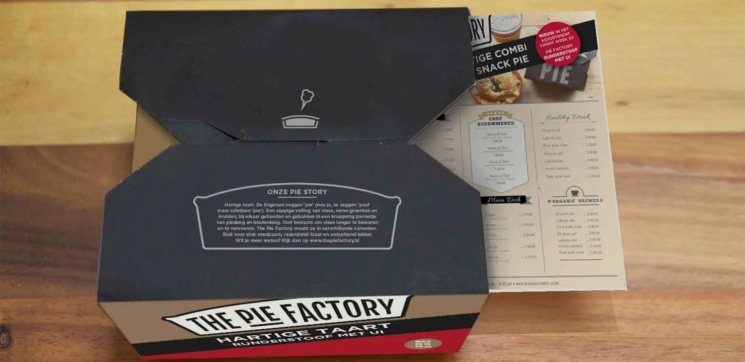 Een zwarte doos van The Pie Factory en een menu op tafel met een afbeelding van verschillende hartige en zoete taarten.