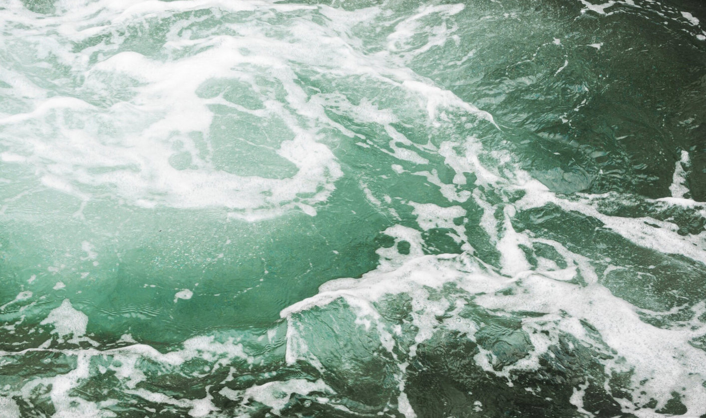 Close-up of choppy ocean water with white foam and swirling patterns.
