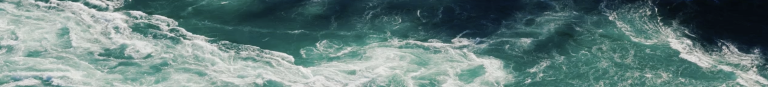 Photo of turbulent ocean waves with white foam.