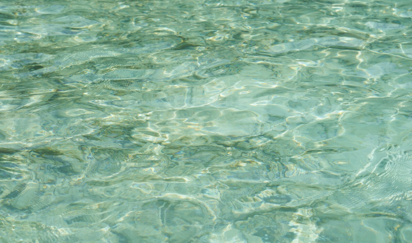 Clear turquoise water with gentle ripples and sunlight reflections.