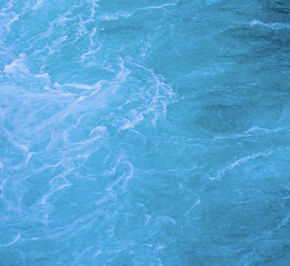 Close-up of blue ocean water with waves and foam.