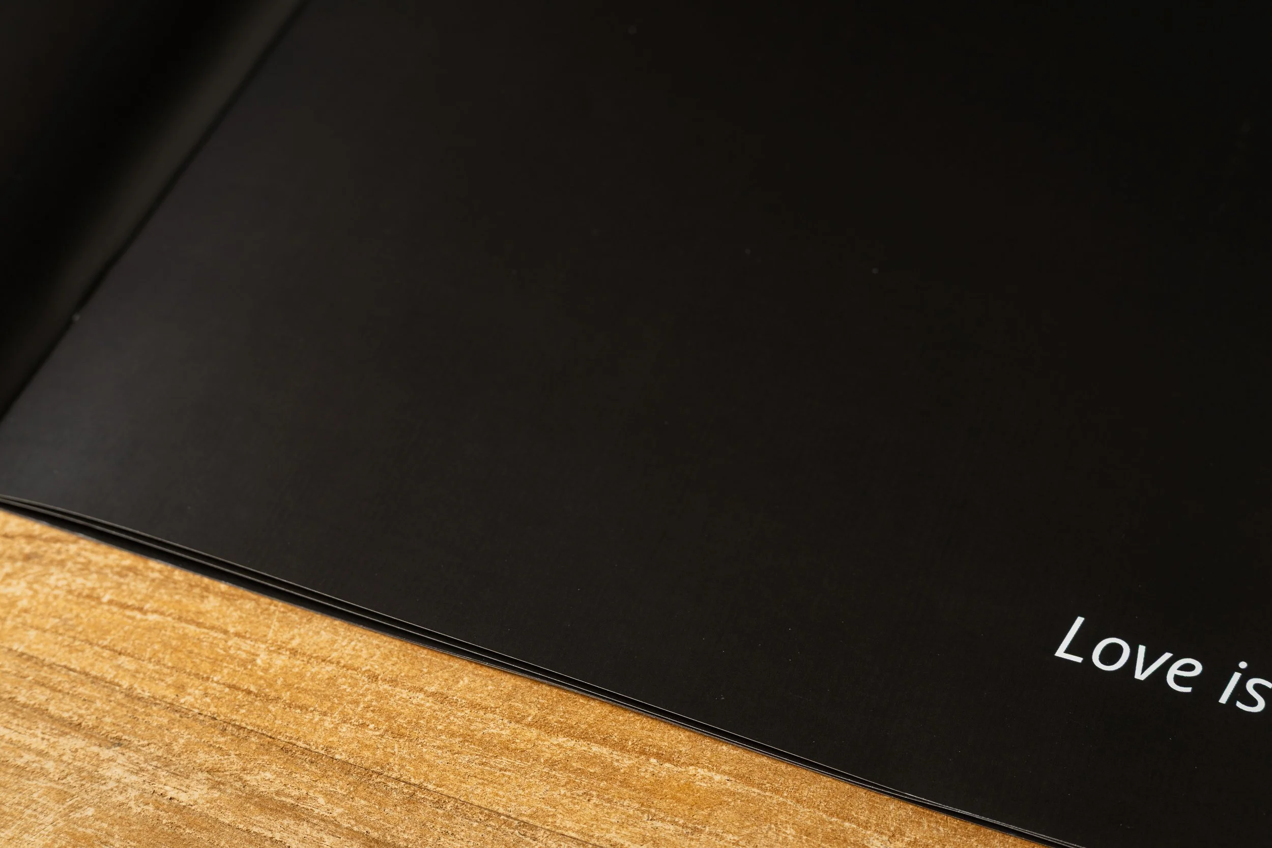 Detail of the photo booklet “Continuance” on a wooden surface