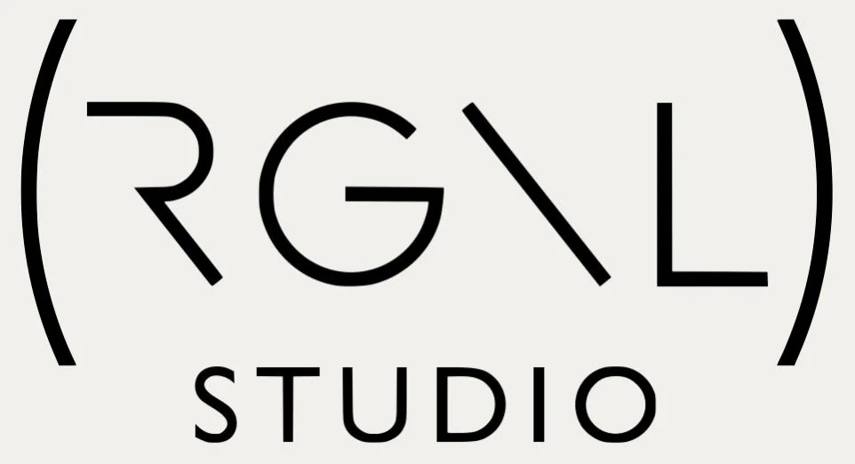 Logo for RGNL Studio with stylized text inside parentheses and the word 'STUDIO' below.