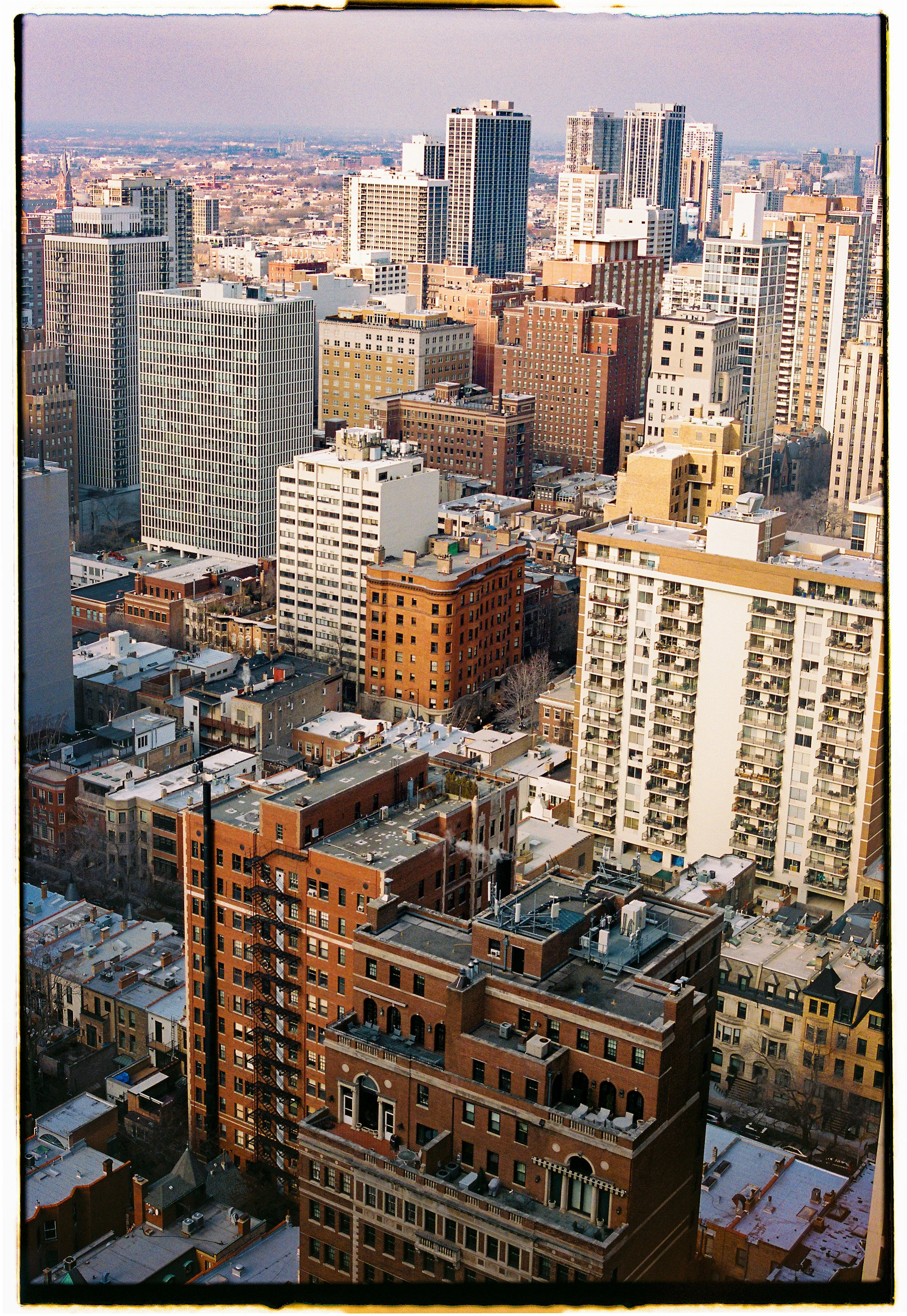 View of a city skyline with high-rise buildings and mid-rise buildings, some with rooftop HVAC units, in a city with a dense urban environment.