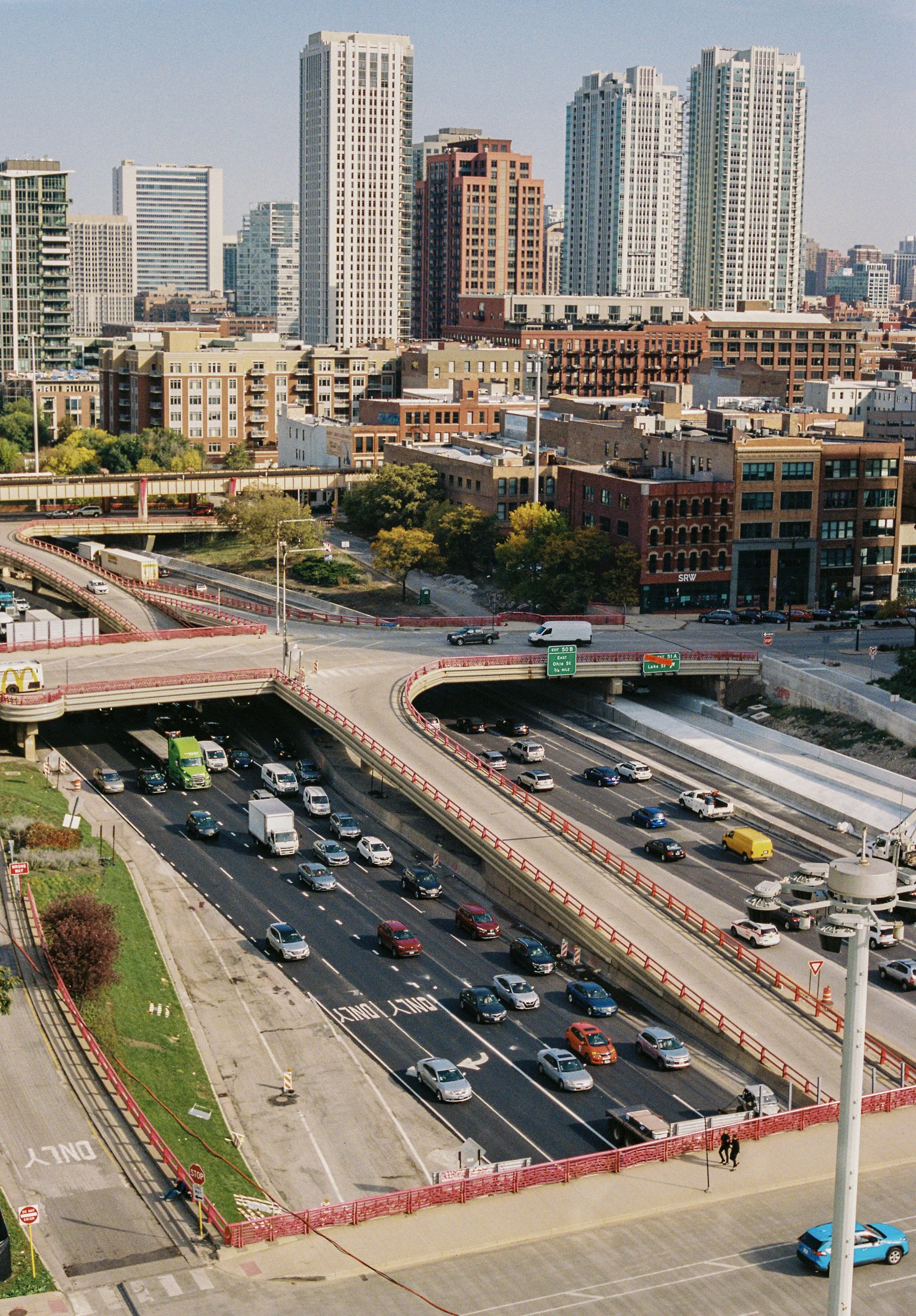 Cityscape with tall skyscrapers, streets, and busy highway with cars in chicago downtown area.
