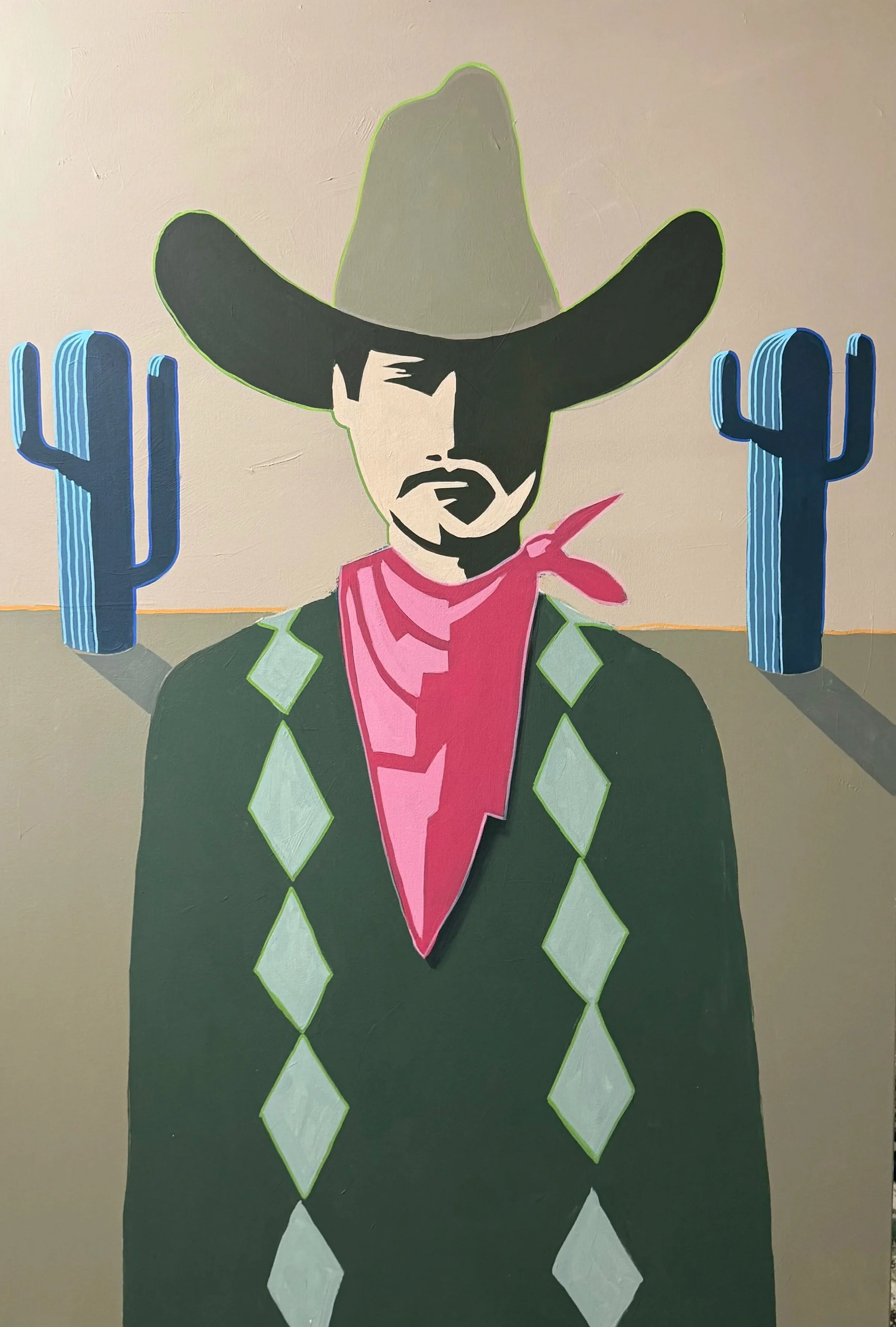 Graffiti art of a cowboy figure with a large sombrero, mustache, and beard, flanked by two cacti on a beige wall.