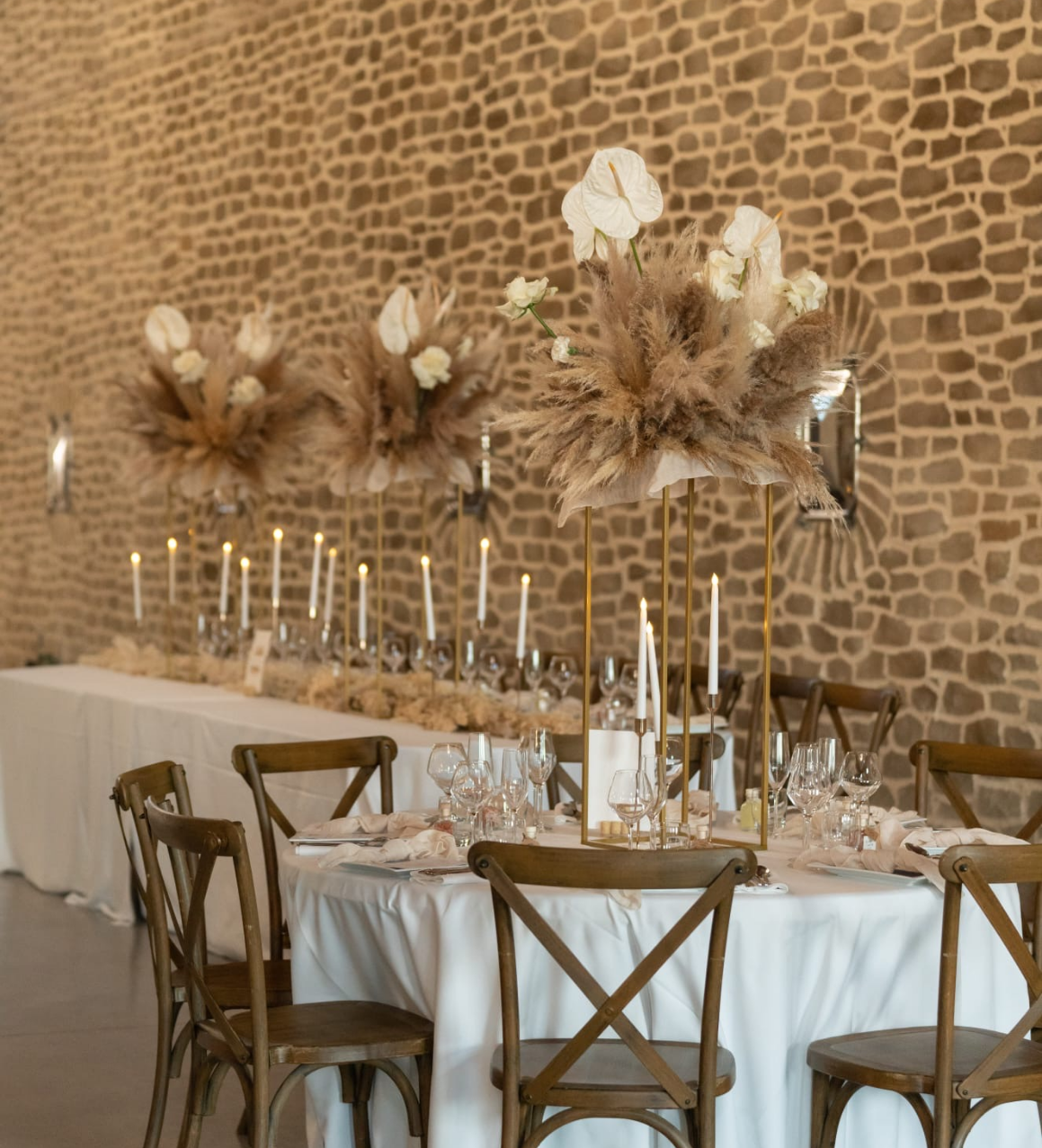 Décoration de table de mariage raffinée avec centre de table haut, structure métal, fleurs en pampa, roses et anthuriums, bougies dorées et papeterie personnalisée, imaginée par A&L Events pour une réception élégante.