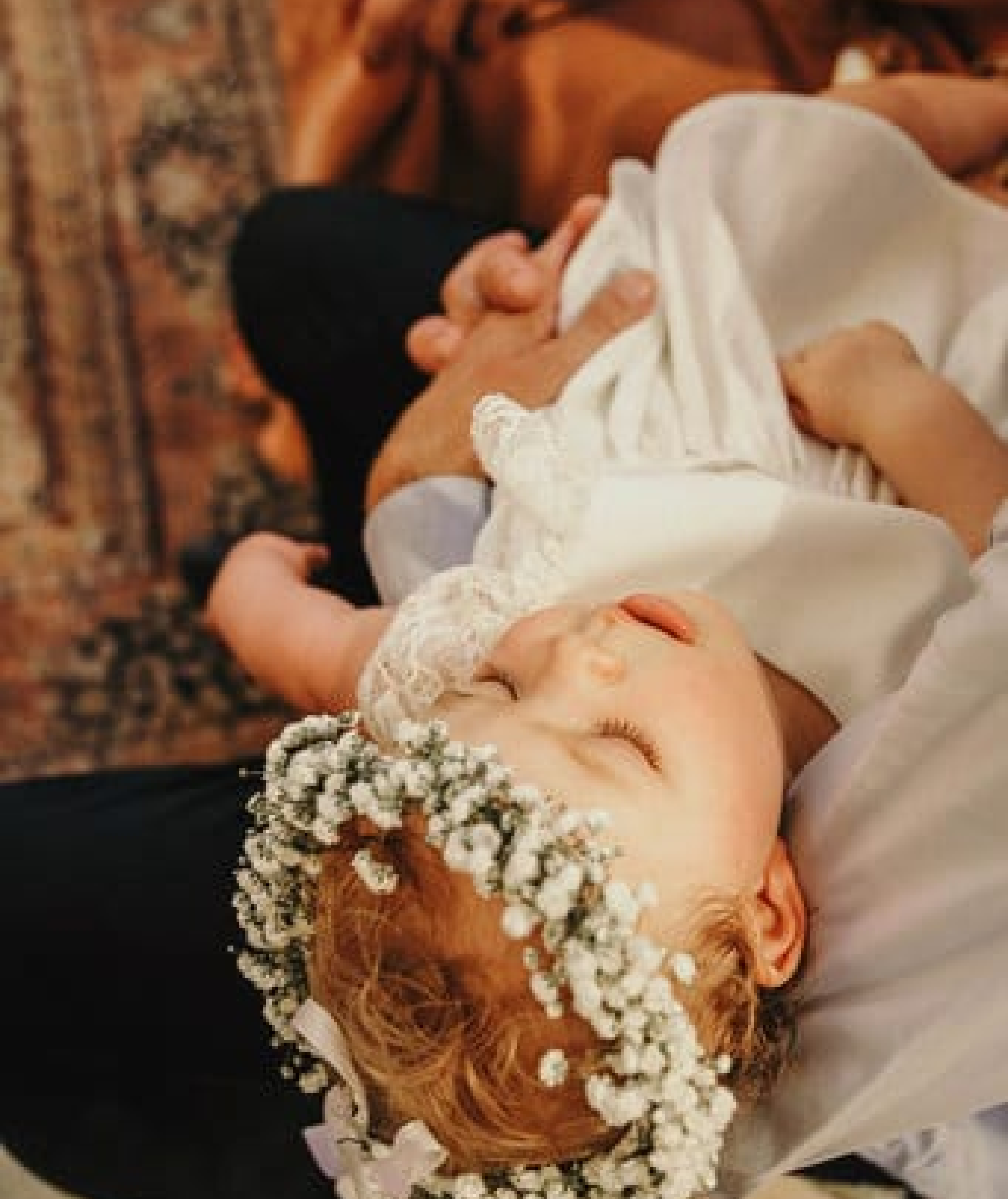 détail raffiné d'un bâpteme haut de gamme à Aix-en-Provence: une couronne de fleurs délicatement posée sur la tête de la petite fille, symbole de douceur et de poésie.