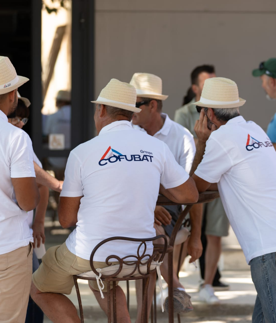 Moment d'échange entre salariés lors d'un événement d'entreprise portant les tee-shirts personnalisés à l'image de leur société.
