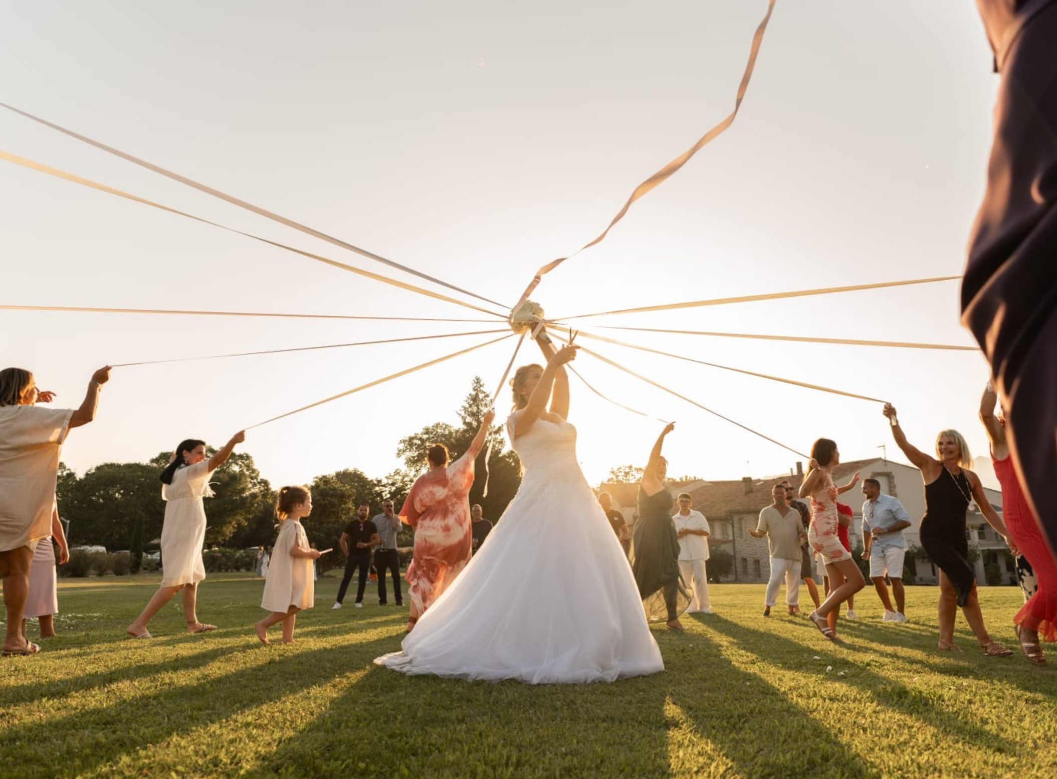 Mariage organisé par A&L Events pour Jennifer & Laurent. Jennifer fait le rituel du ruban chaque invitées tient un ruban et tourne autour d'elle et elle coupe les rubans les uns après les autres pour qu'il en reste qu'un et ça révèle la gagnante