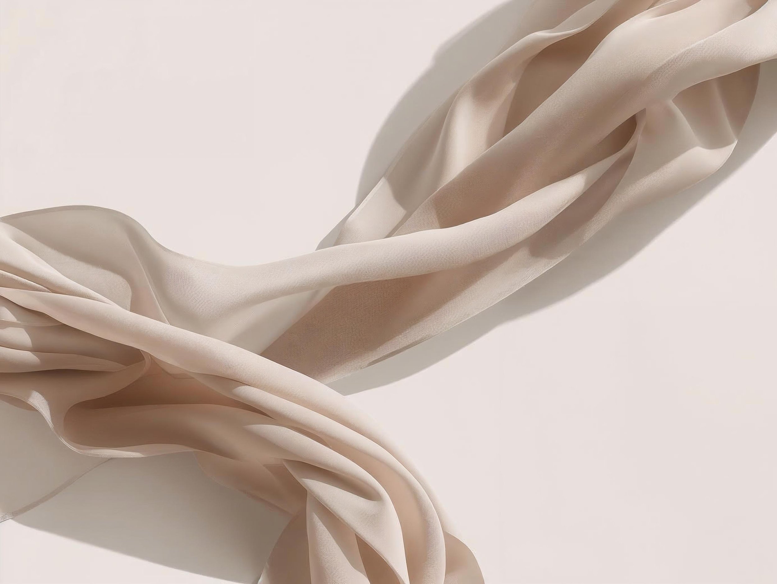 Cream-colored silky fabric on a white surface