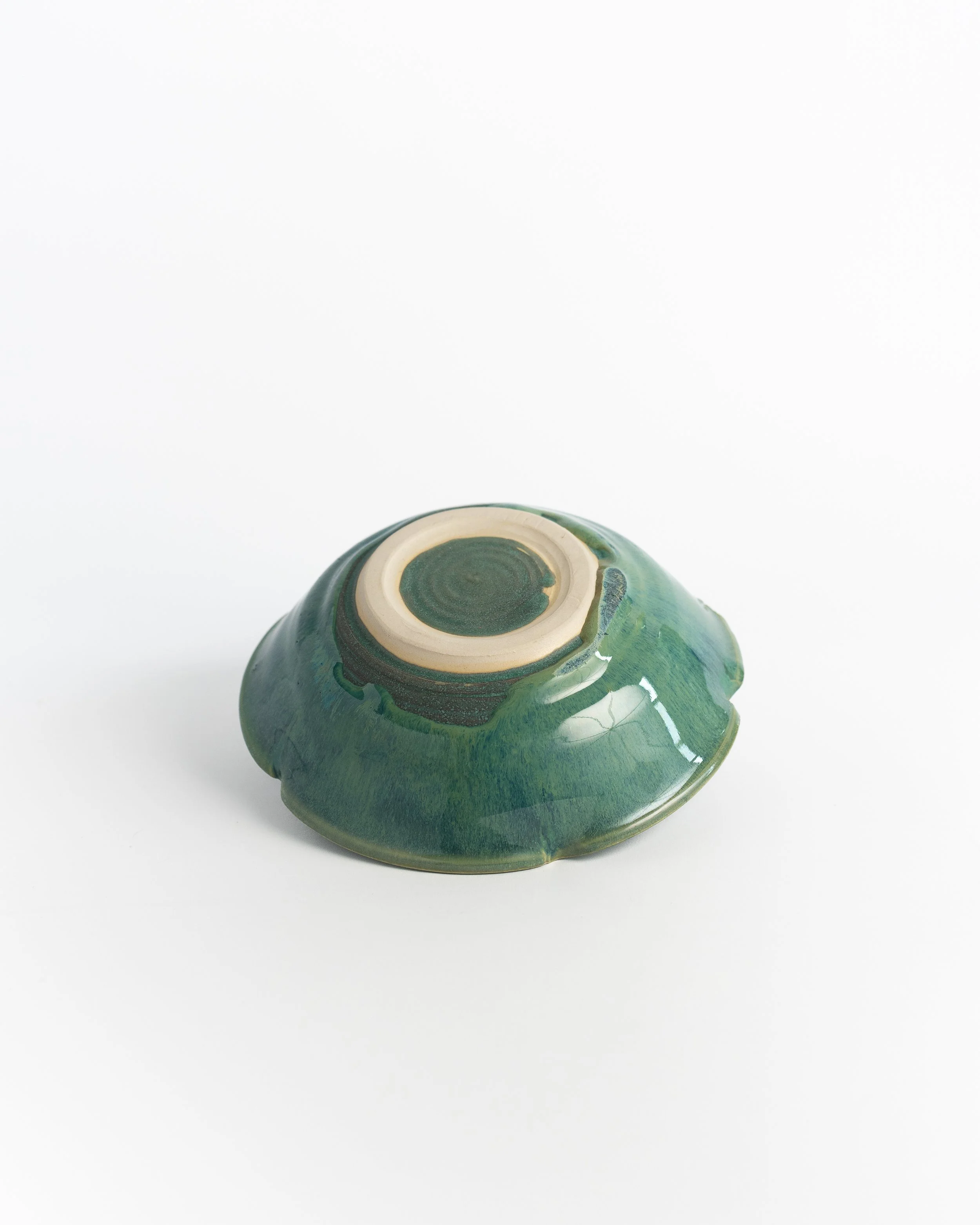 Underside of Green Petal Bowl showing the unglazed foot and maker's mark.