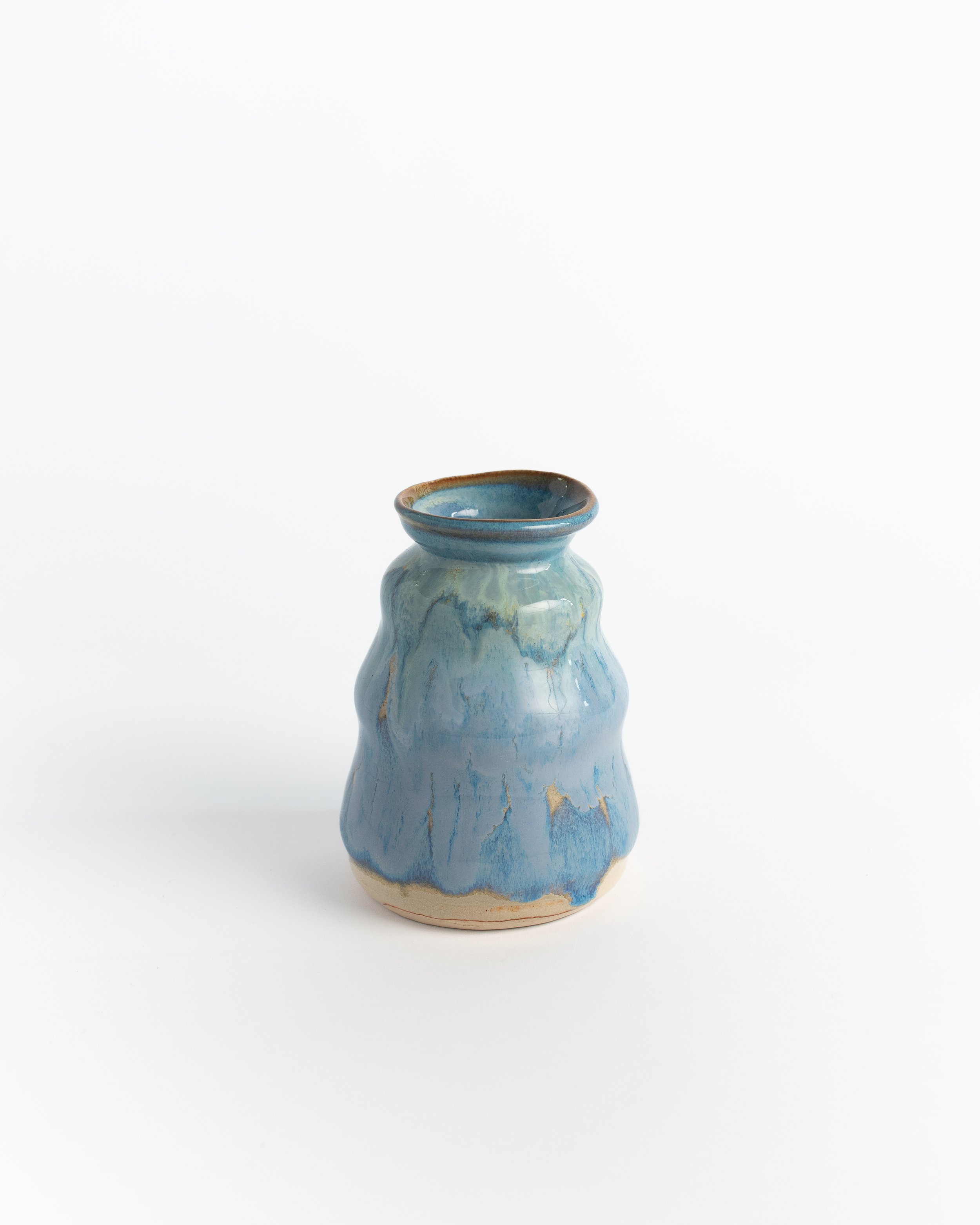 Small ceramic vase in layered blues with a softly rippled body and a flared rim.