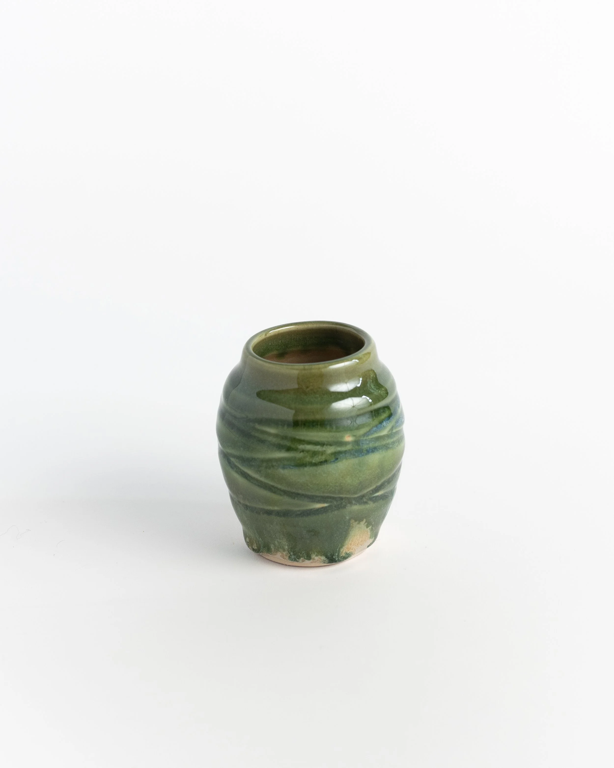 Small ceramic vase in mottled green with a hand-twisted, softly ribbed body.