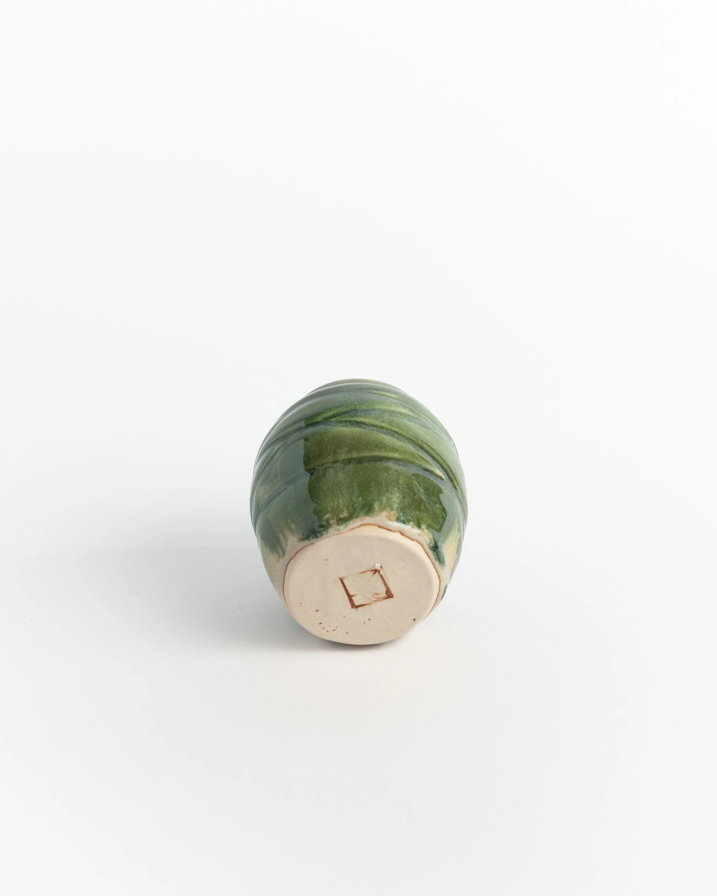 Underside of Twisted Green showing the unglazed foot and maker's mark.