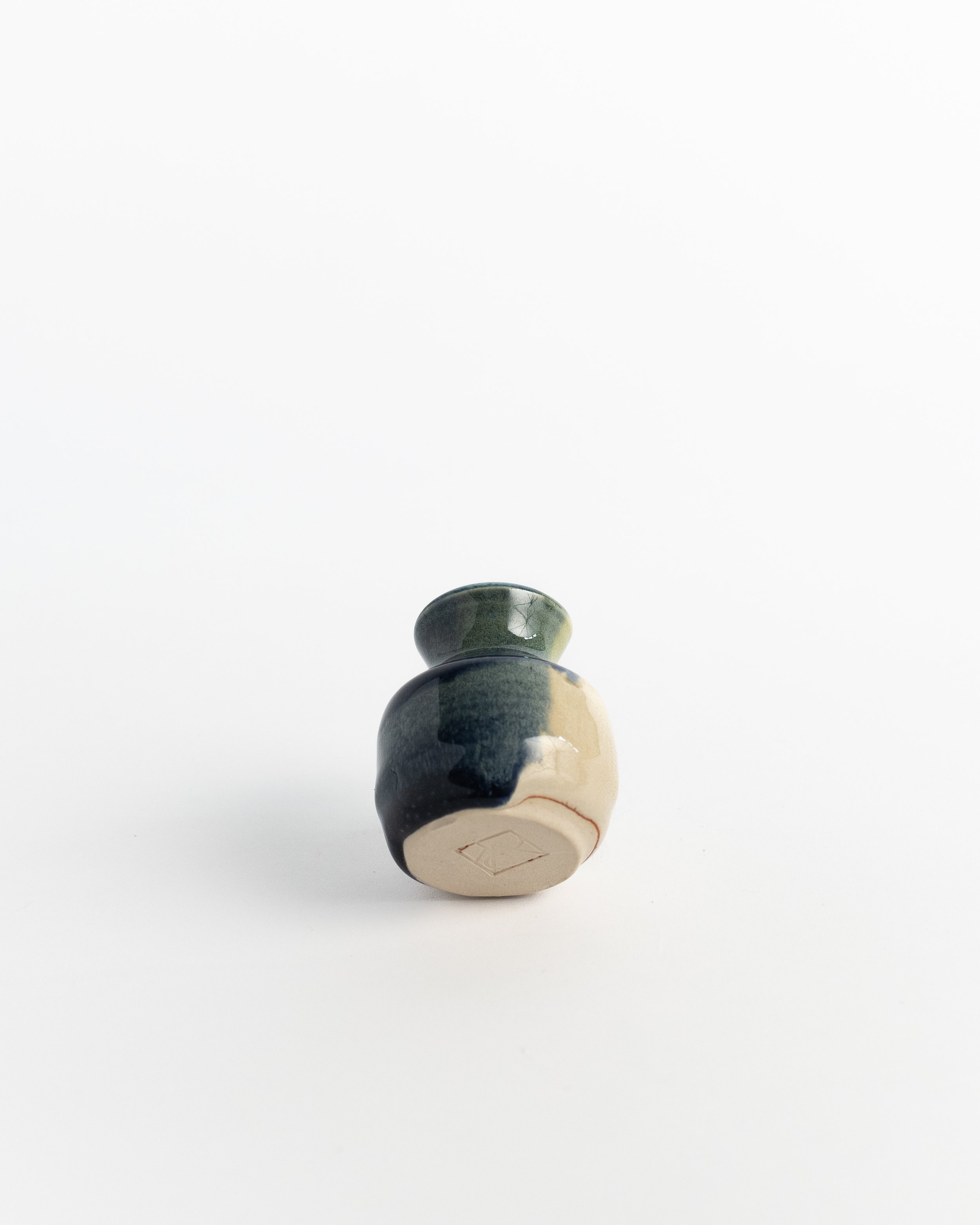 Underside of Tidepool Bud Vase showing the unglazed foot and maker's mark.