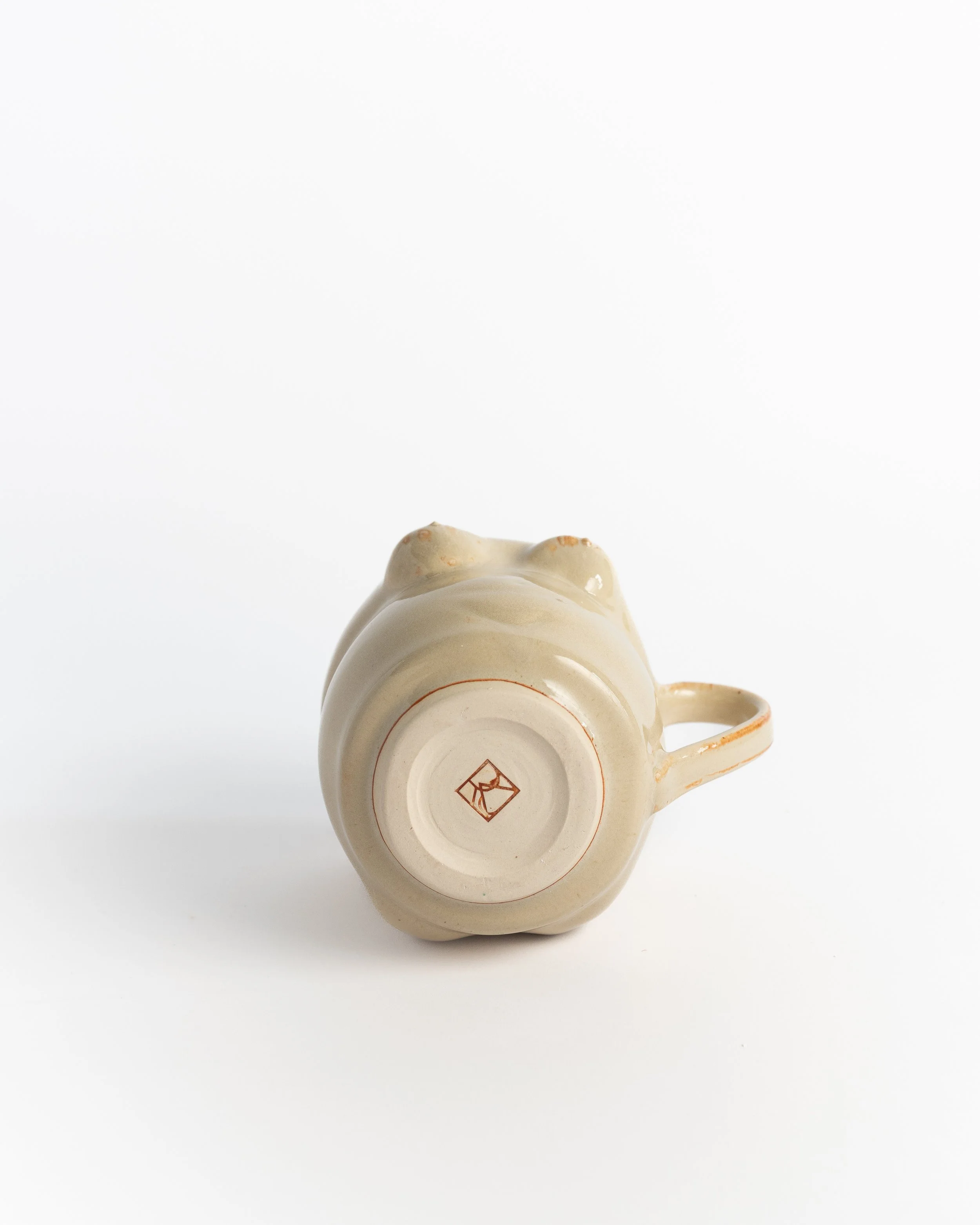 Underside of Figure Mug II showing the unglazed foot and maker's mark.