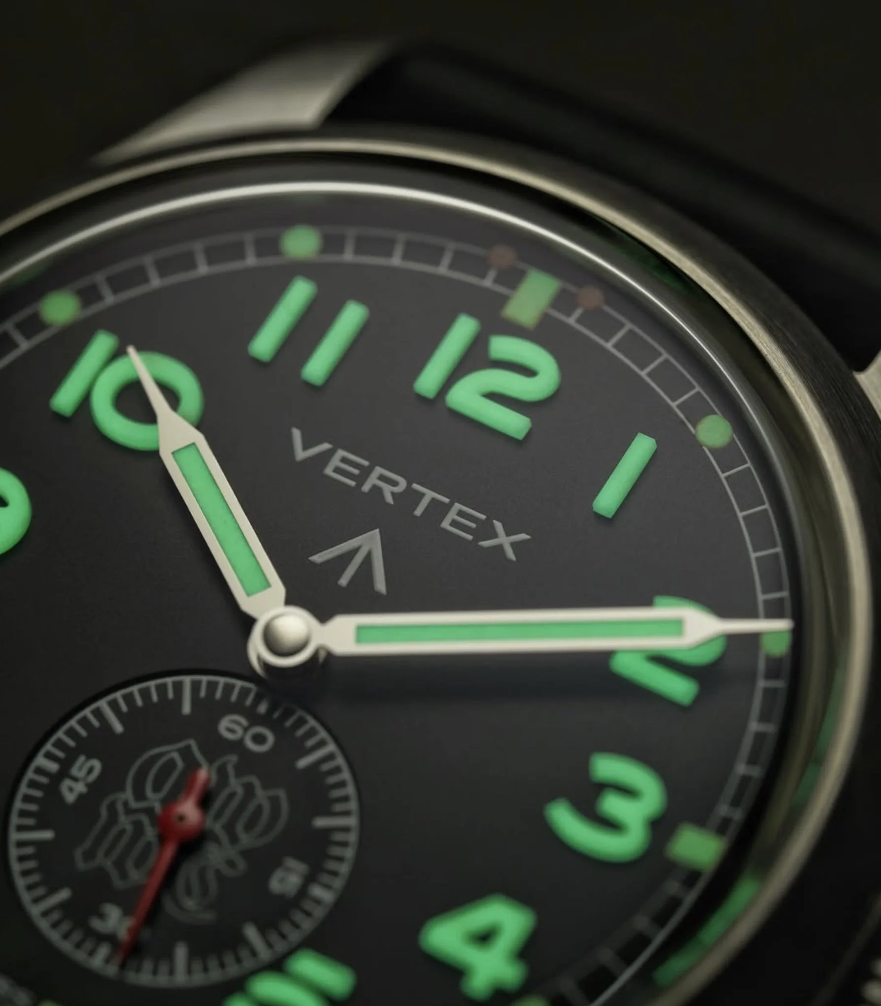 Close-up of a wristwatch with glowing green numerals and hands, showing the time around 10:12.