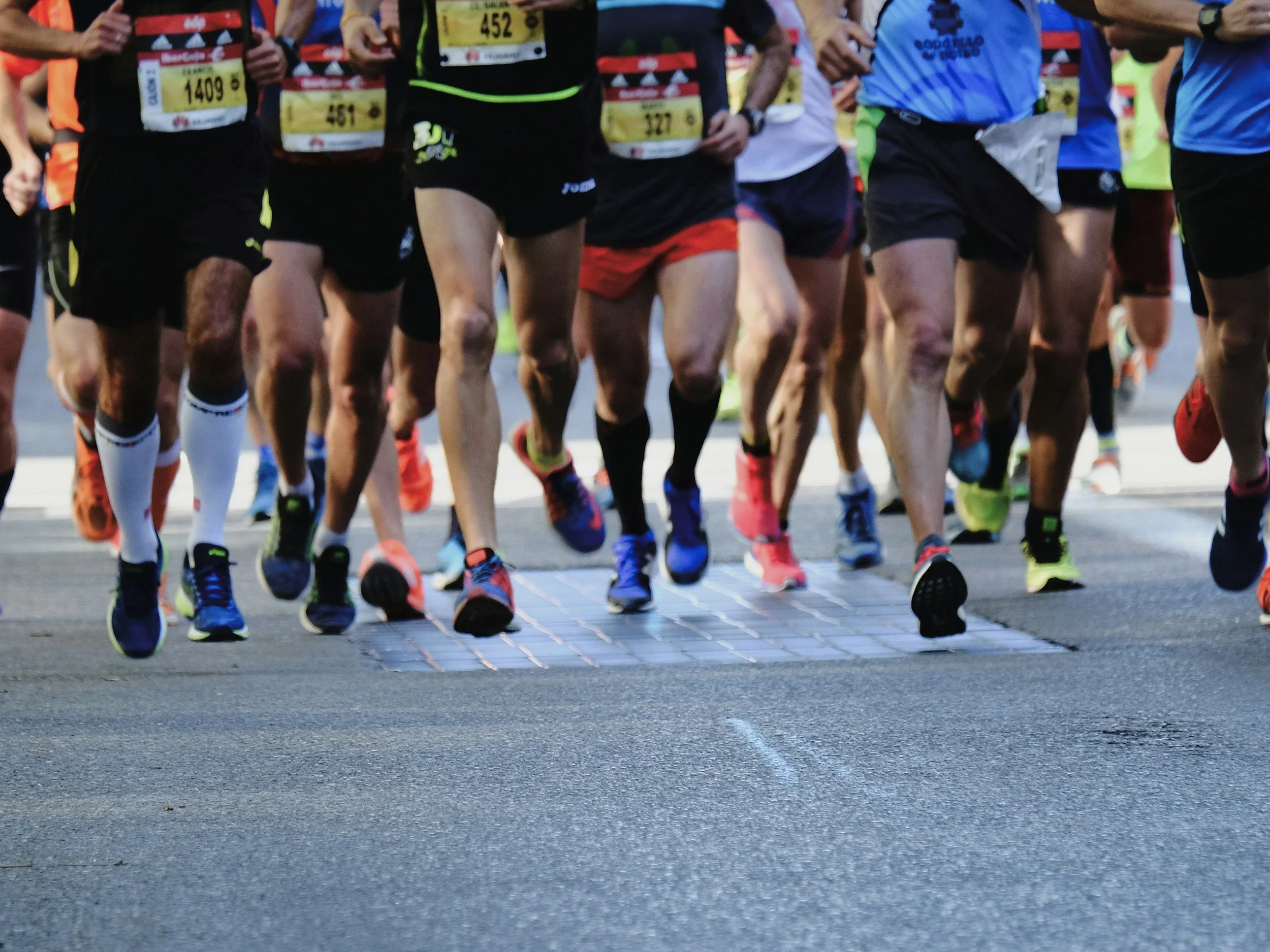 Group of runners at start line — nervous system performance coaching for athletes